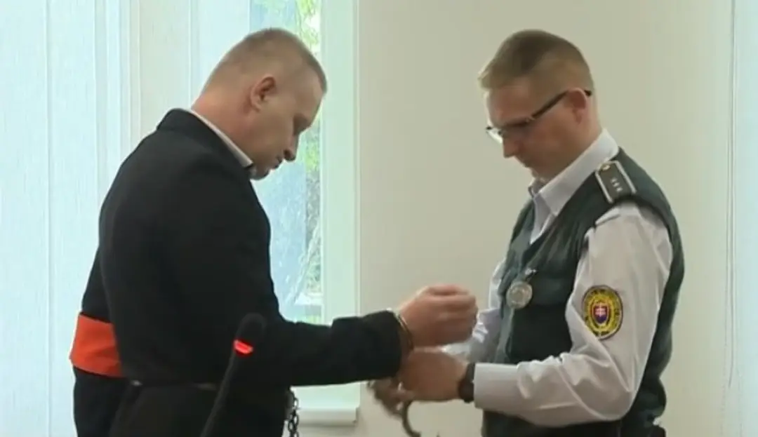 Na snímke je muž odsúdený za marihuanu, vedla neho je policajt, ktory mu zapina puta.