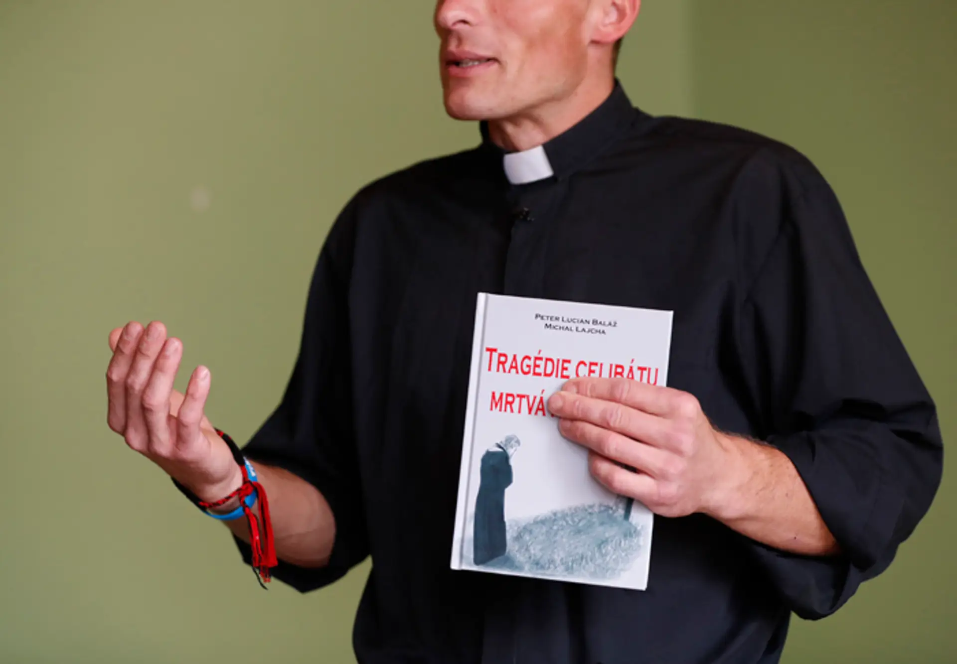 Michal Lajcha drží v ruke výtlačok knihy Tragédia celibátu: Mŕtva manželka, ktorej je spoluautorom.