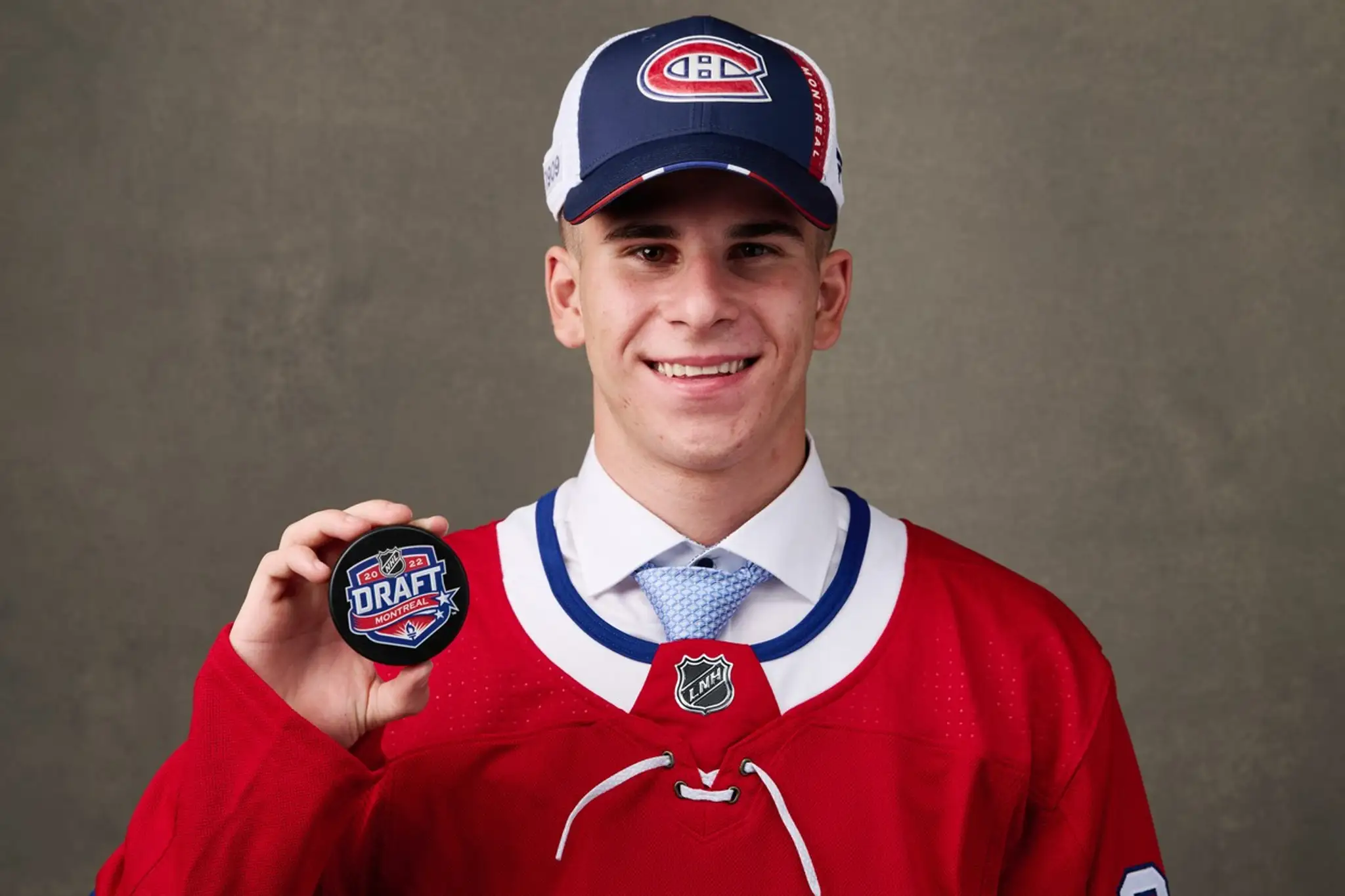 Filip Mešár pózuje s pukom po 1. kole NHL draftu 2022.