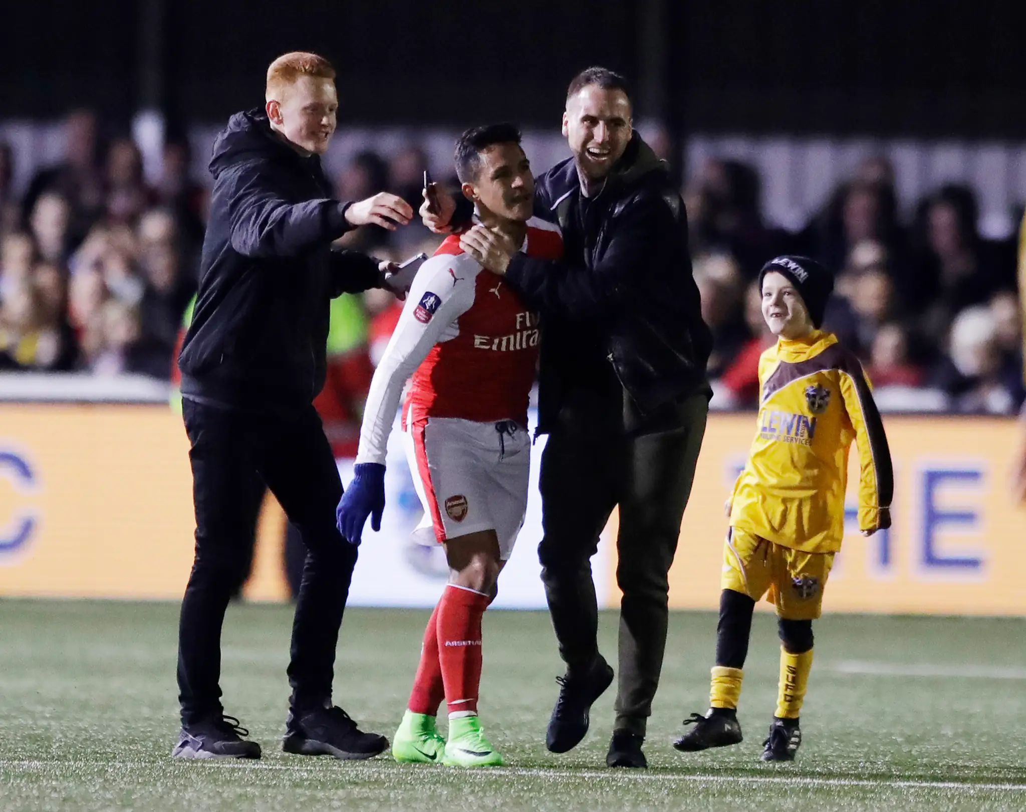 Alexis Sánchez z Arsenalu v obkolesení fanúšikov Suttonu po zápase FA Cupu.