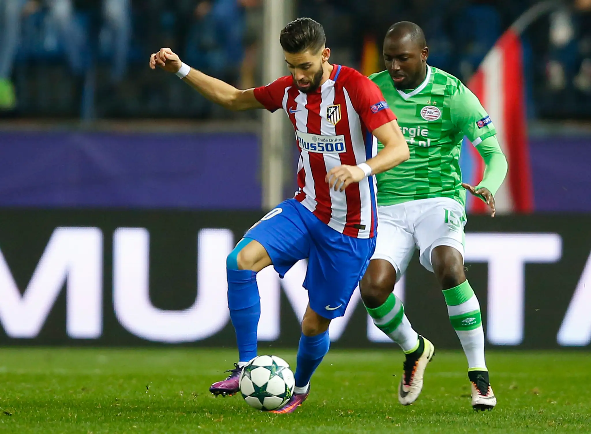 Hviezdu Atlética Madrid Yannicka Carrasca (v popredí) sa v dueli LM snaží zastaviť bek PSV Eindhoven Jetro Willems.