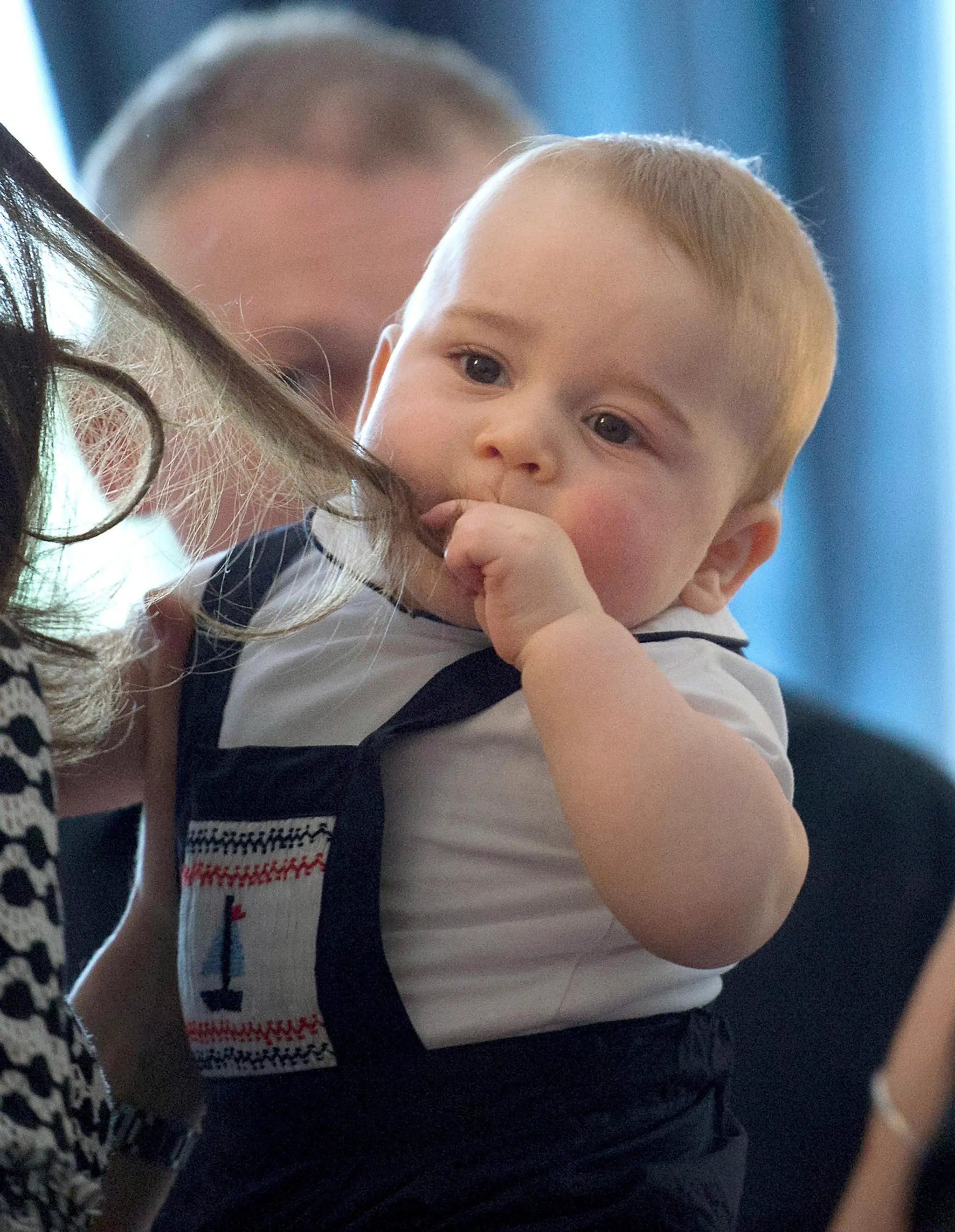 Britský princ George sa hrá s vlasmi Kate 9. apríla 2014.