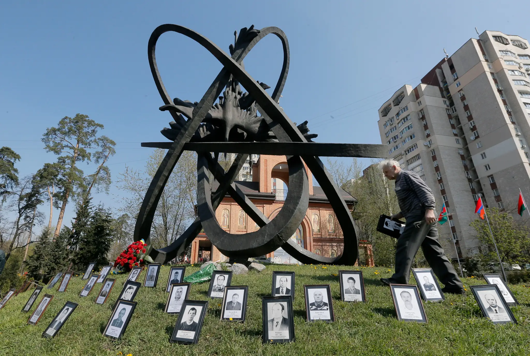 Príbuzný obete havárie v Černobyle kladie fotografiu k pamätníku obetiam černobyľskej havárie v Kyjeve. 27. apríla
