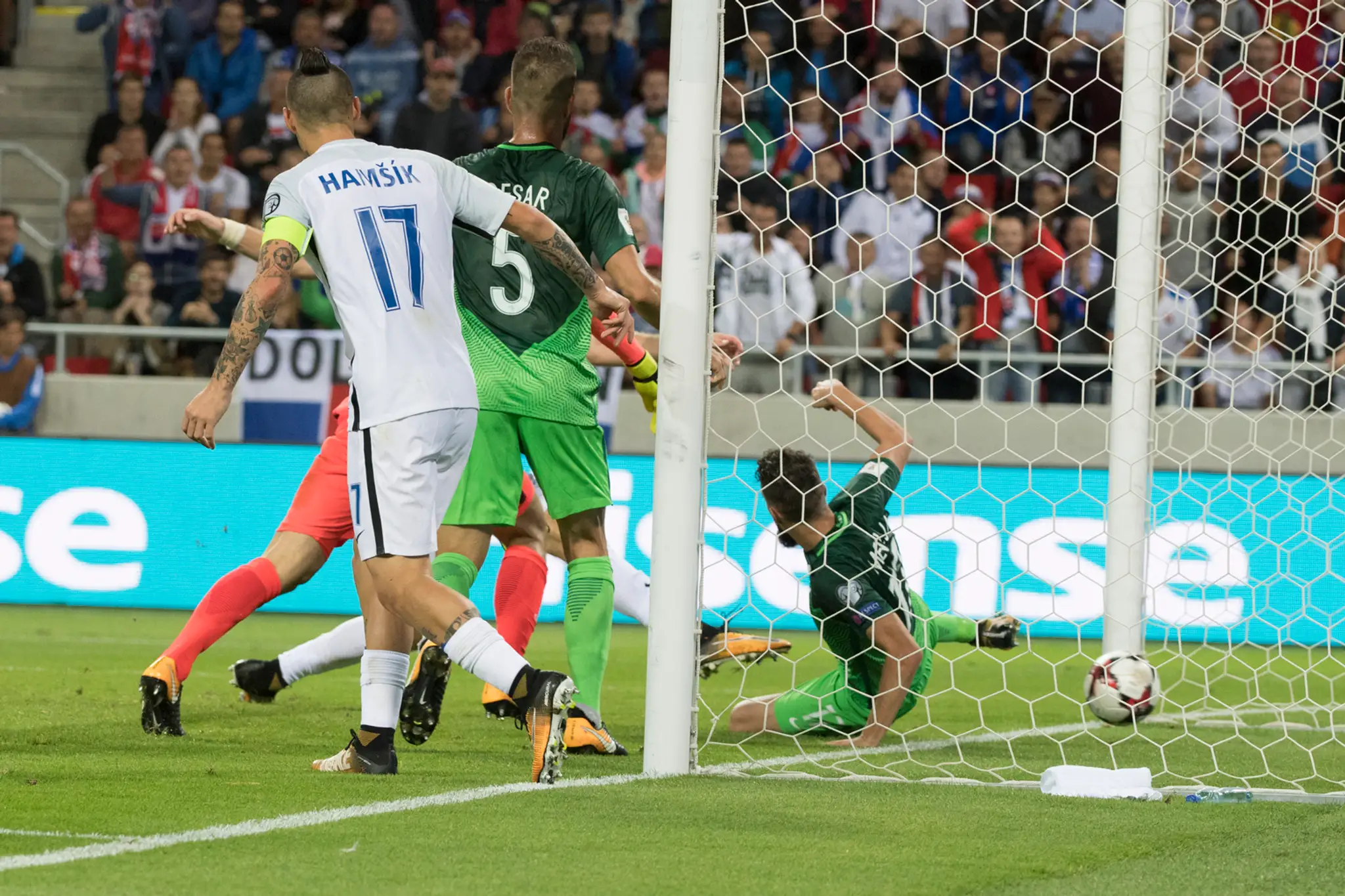 Na snímke skrytý za hráčmi Adam Nemec (Slovensko) strieľa gól.