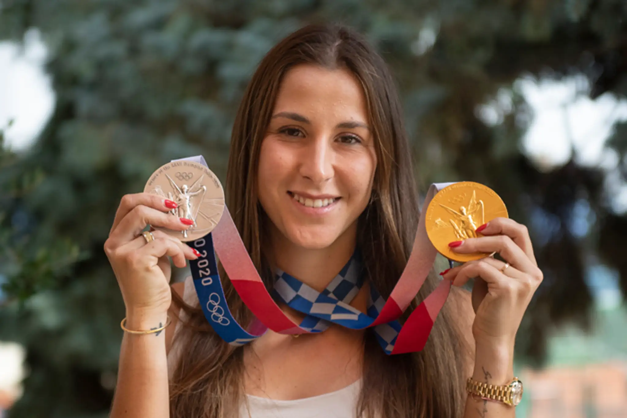 Belinda Benčičová pózuje so zlatou a striebornou medailou z OH v Tokiu.