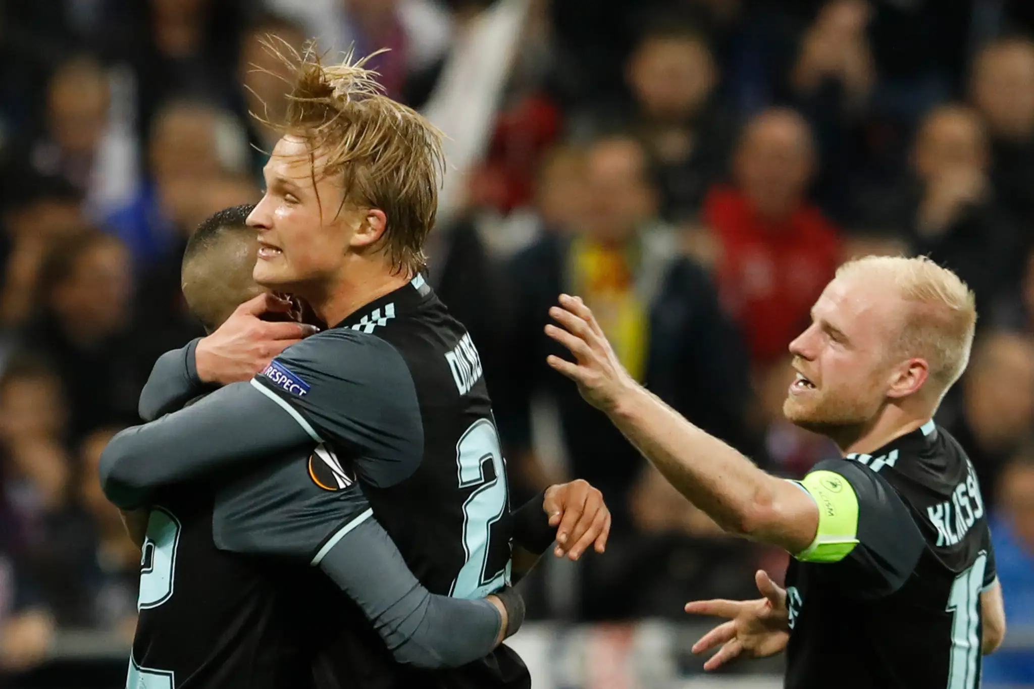 Kaspera Dolberga z Ajaxu objíma v odvete semifinále EL spoluhráč Hakim Ziyech (vľavo), prizerá sa Davy Klaassen.