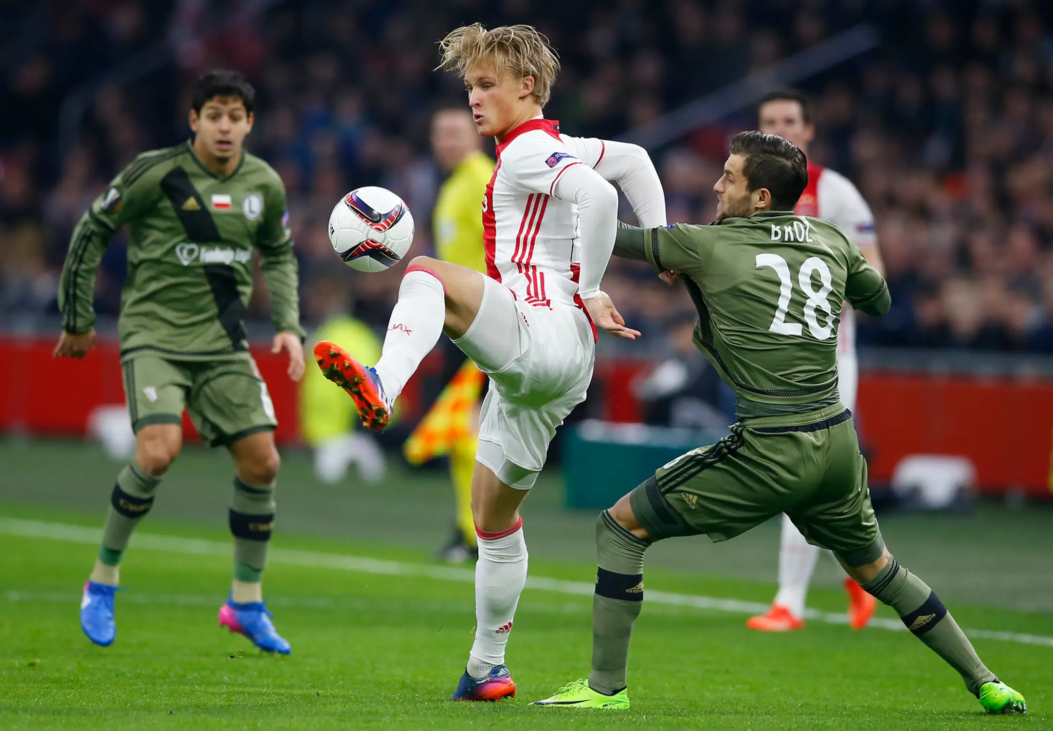 Hviezdu Ajaxu Kaspera Dolberga (vľavo) atakuje Lukasz Broz z Legie v šestnásťfinále EL.