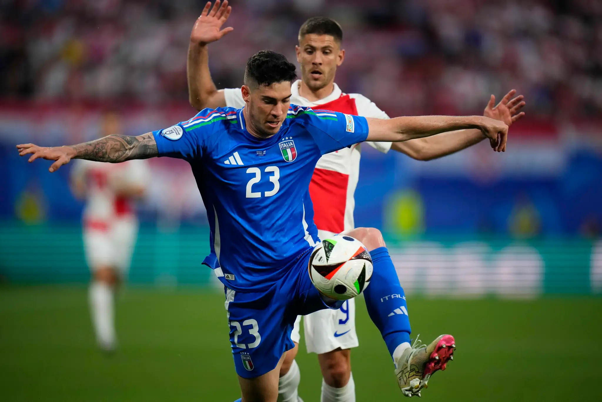 Zľava Talian Alessandro Bastoni a Chorvát Andrej Kramarič v dueli na ME 2024.