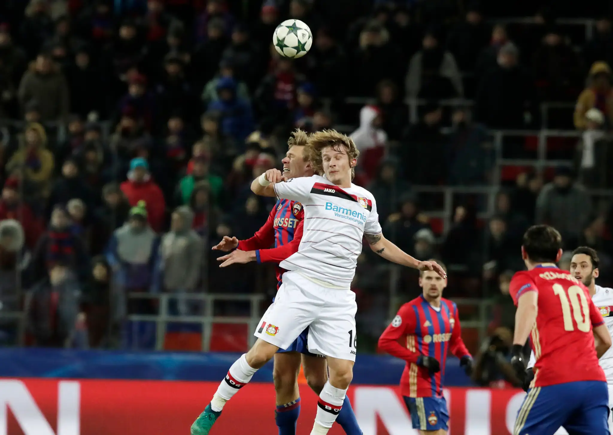 Pontus Wernbloom (vzadu) z CSKA Moskva v hlaviškovom súboji s Tinom Jedvajom z Bayeru Leverkusen v dueli LM.