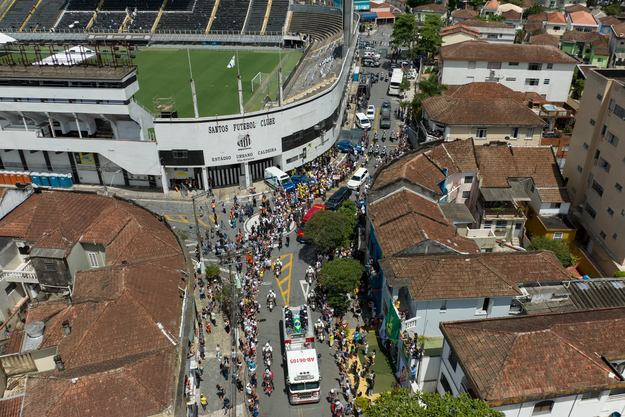 Rakva s pozostkami zosnulého brazílskeho legendárneho futbalistu Pelého je zakrytá brazílskou vlajkou a vlajkou klubu Santos FC počas prevozu zo štadióna Vila Belmiro na cintorín Memorial Necropole Ecumenica.