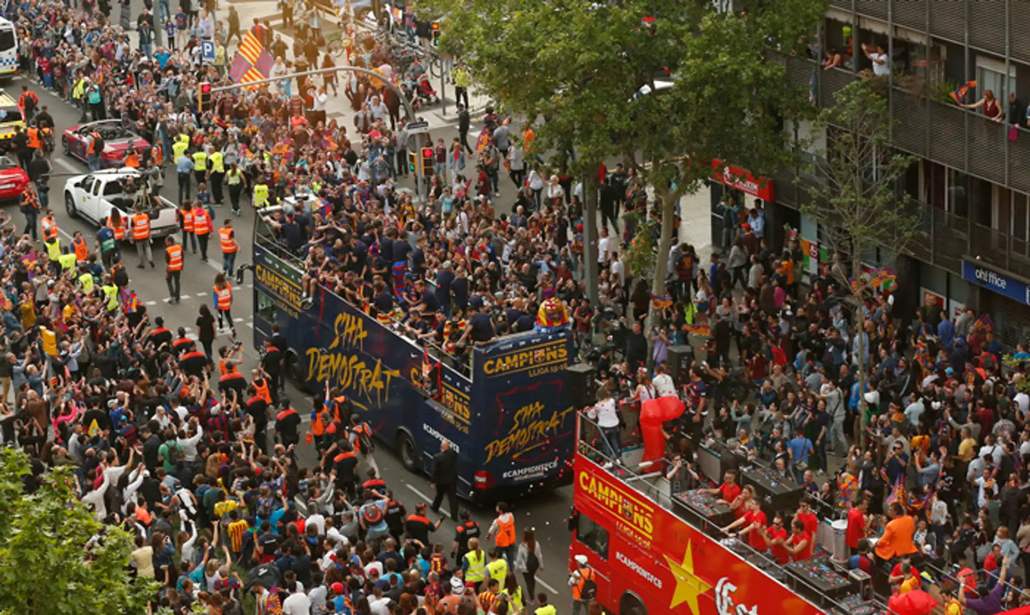 Hráči FC Barcelona oslavujú v otvorenom autobuse ligový titul v uliciach mesta.