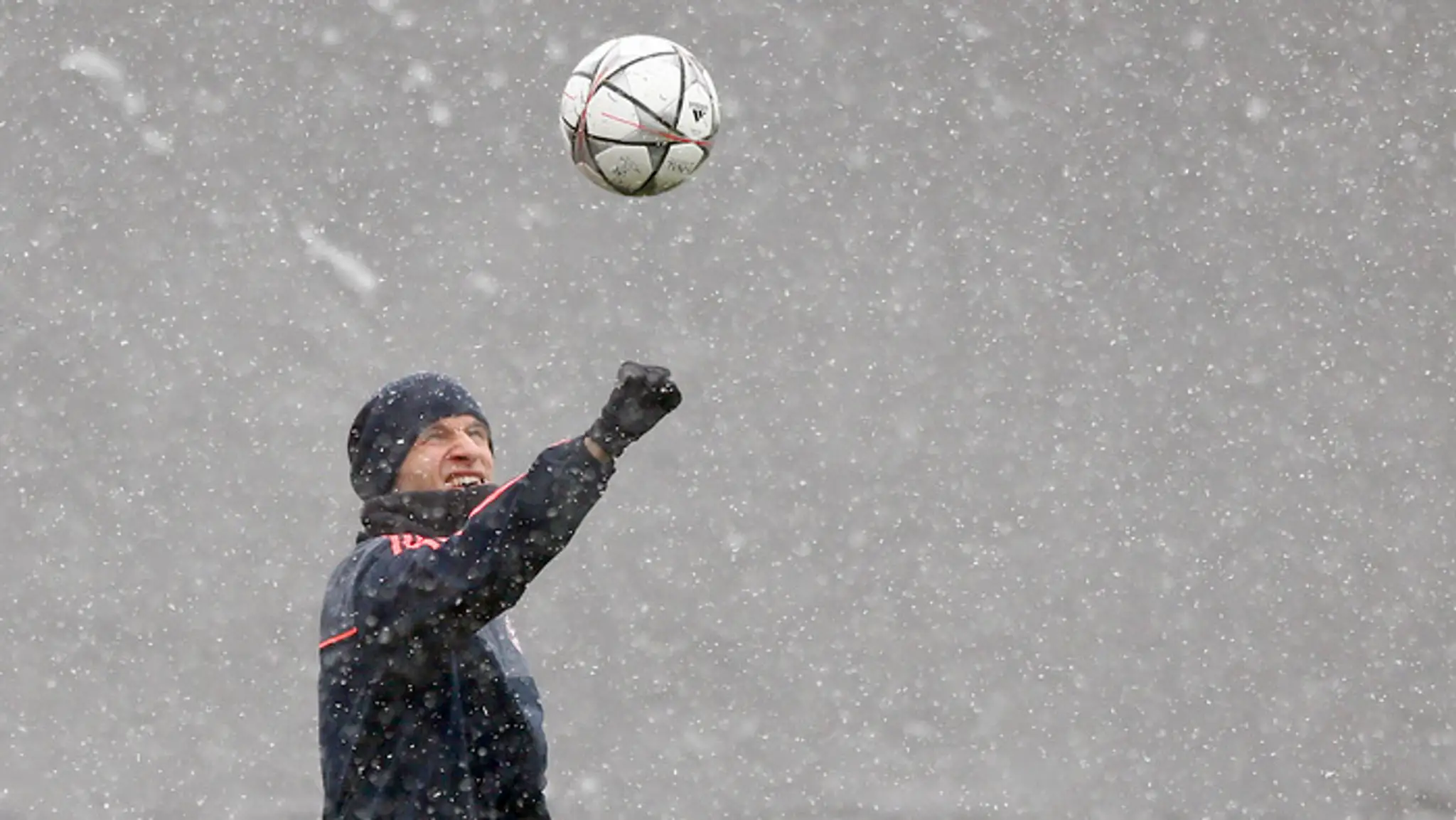 Futbalista Bayernu Mníchov Thomas Müller žongluje s loptou na tréningu počas hustého sneženia pred odvetou LM.
