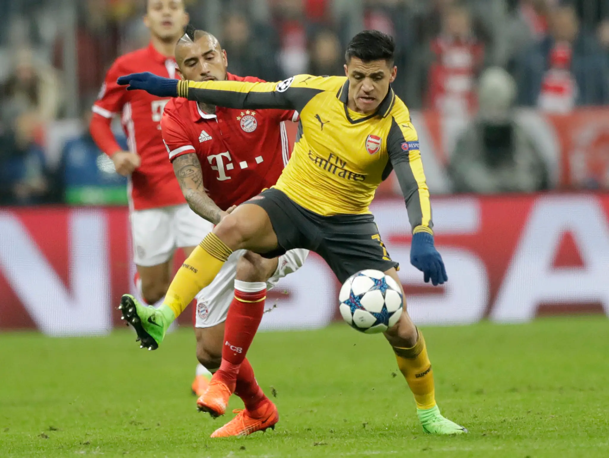 Záložník Arsenalu Alexis Sánchez si stráži loptu pred Arturom Vidalom z Bayernu v osemfinále LM.