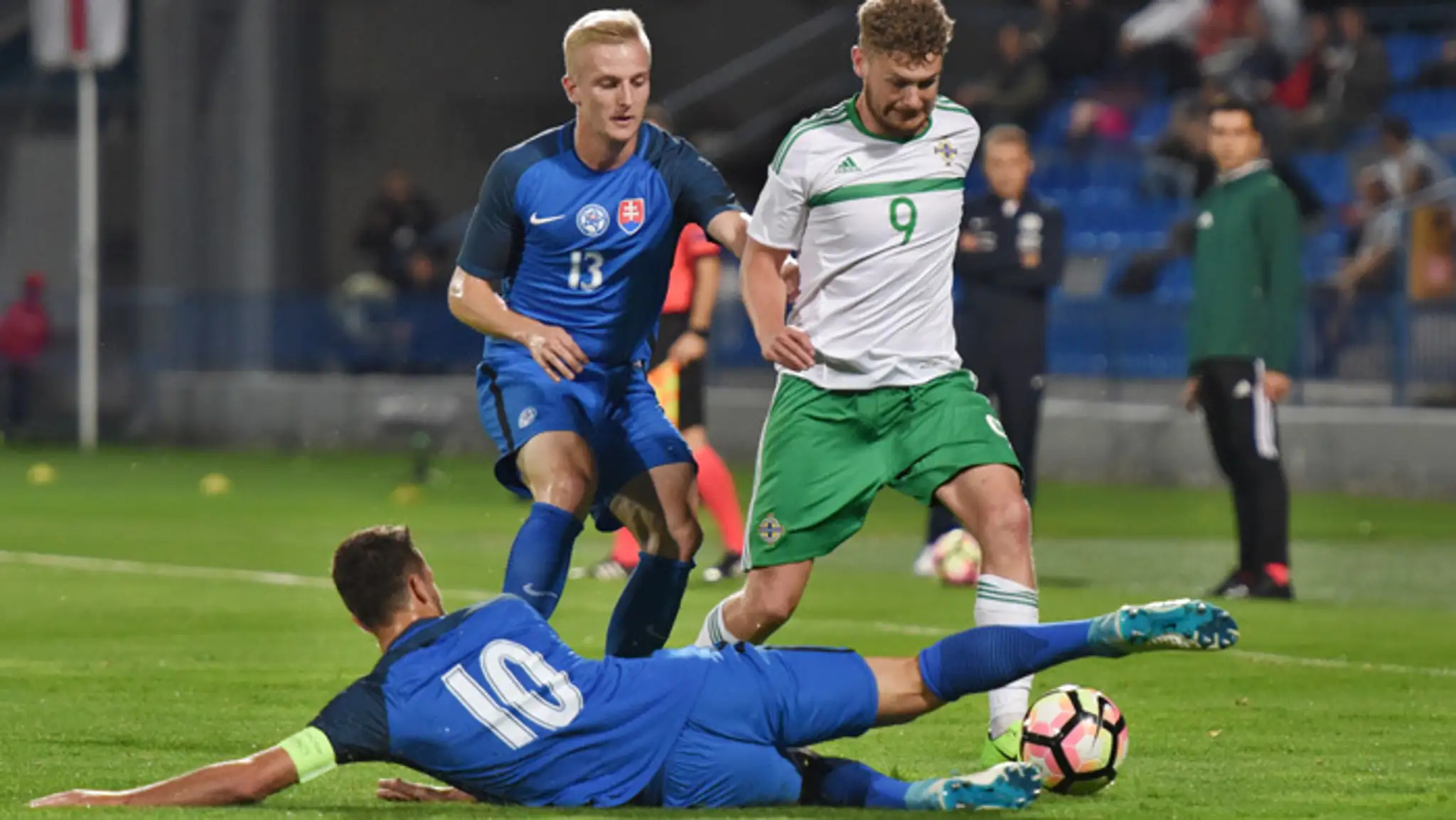 Na snímke vľavo hráč Slovenska Michal Sipľak, vpravo hráč Severného Írska Ben Kennedy a dole kapitán Slovenska Jakub Hromada.