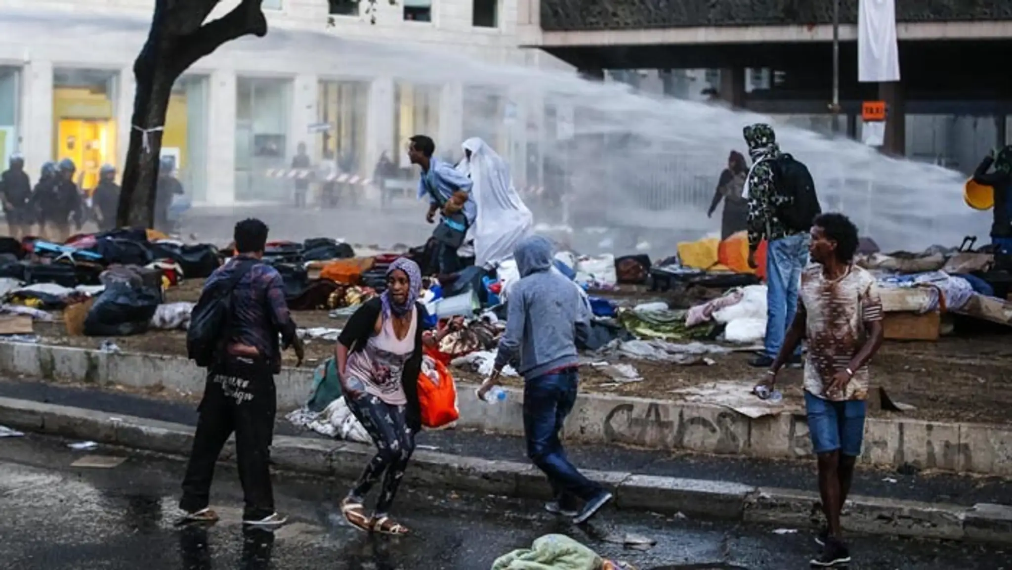 Talianski policajti rozháňajú vodnými delami protestujúcich migrantov v centre Ríma.