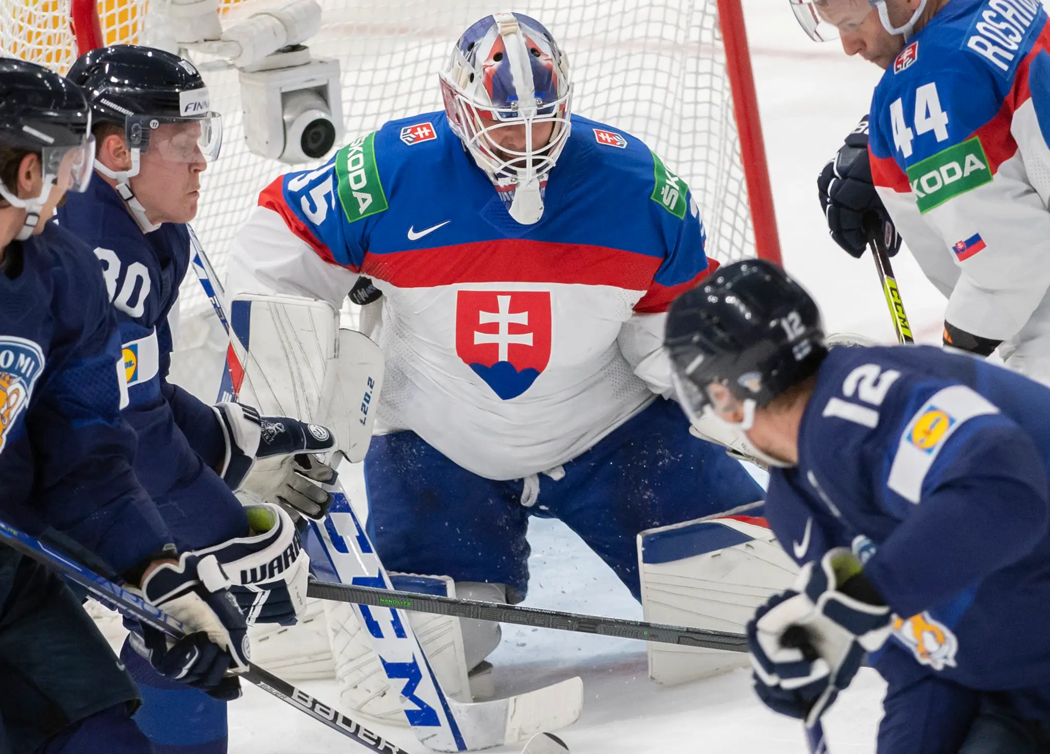 Na snímke slovenský brankár Adam Húska (uprostred) dostáva gól po teči Fína Marka Anttilu (vpravo) vo štvrťfinále MS 2022.