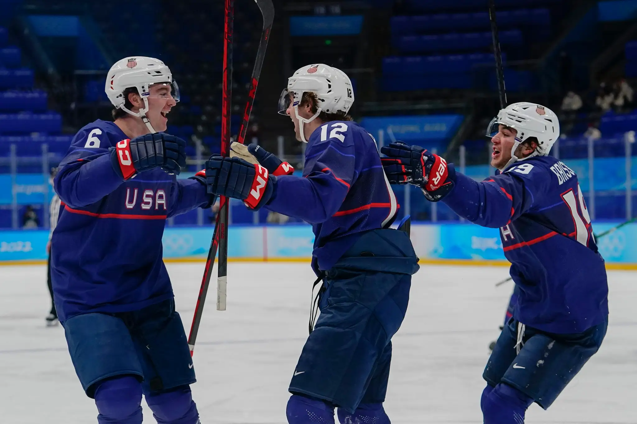 Zľava Američania Nick Perbix, Sam Hentges a Brendan Brisson oslavujú gól vo štvrťfinále ZOH 2022 proti Slovensku.