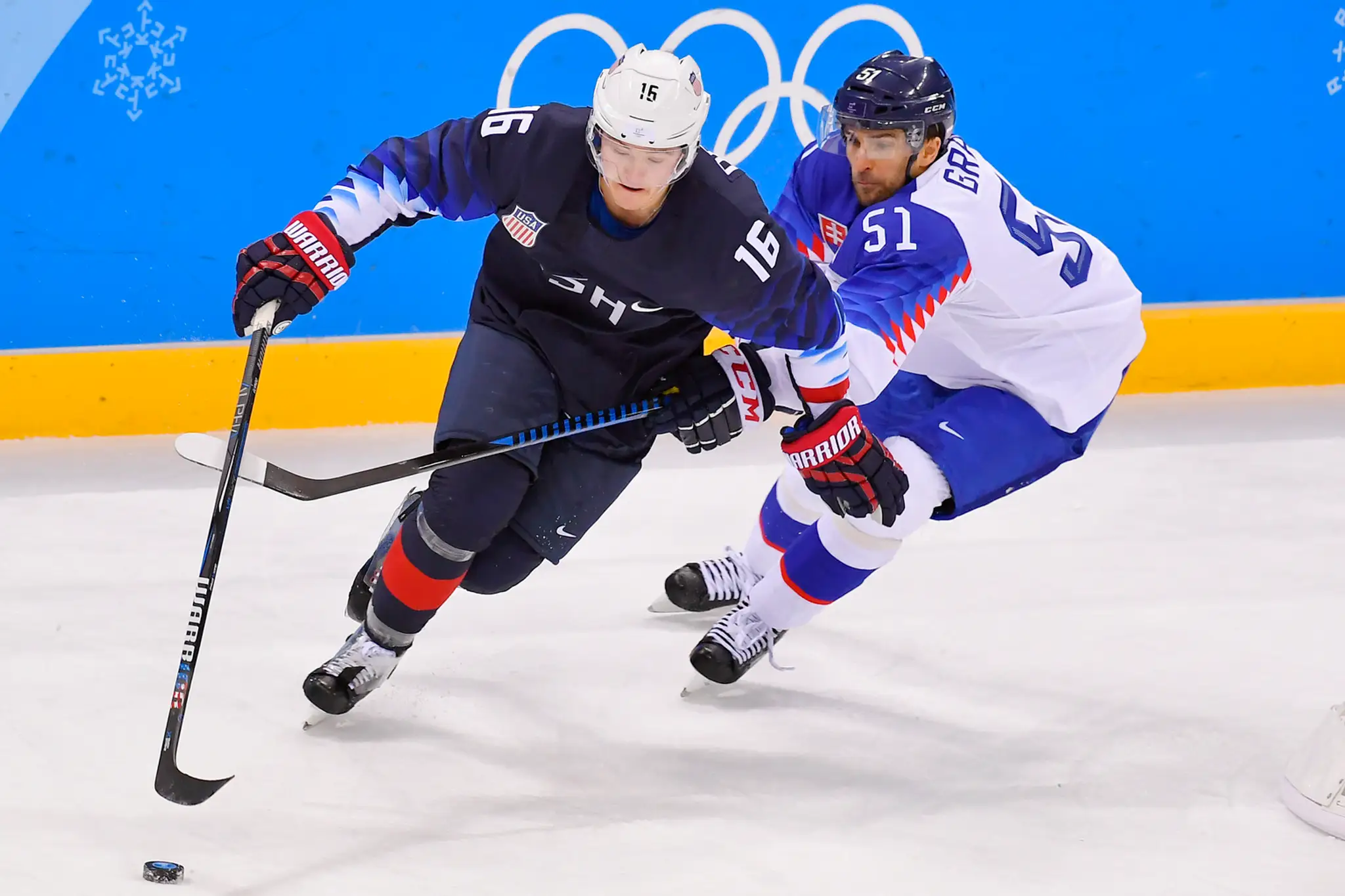 Slovenský obranca Peter Čerešňák sa snaží vyhodiť puk pred našou bránkou v zápase proti USA na ZOH 2018.