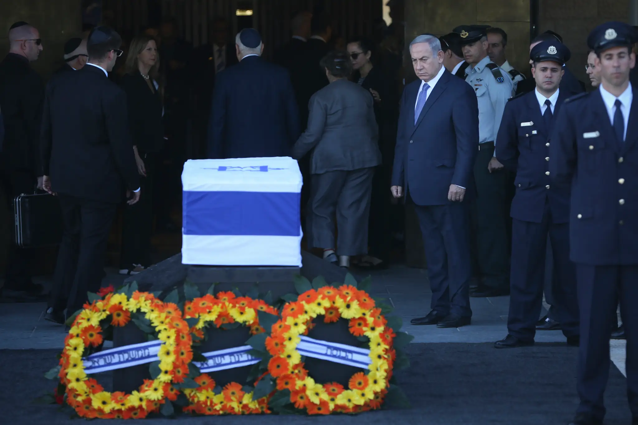 Izraelský premiér Benjamin Netanyahu stojí vedľa truhly s pozostatkami zosnulého bývalého izraelského prezidenta Šimona Peresa.