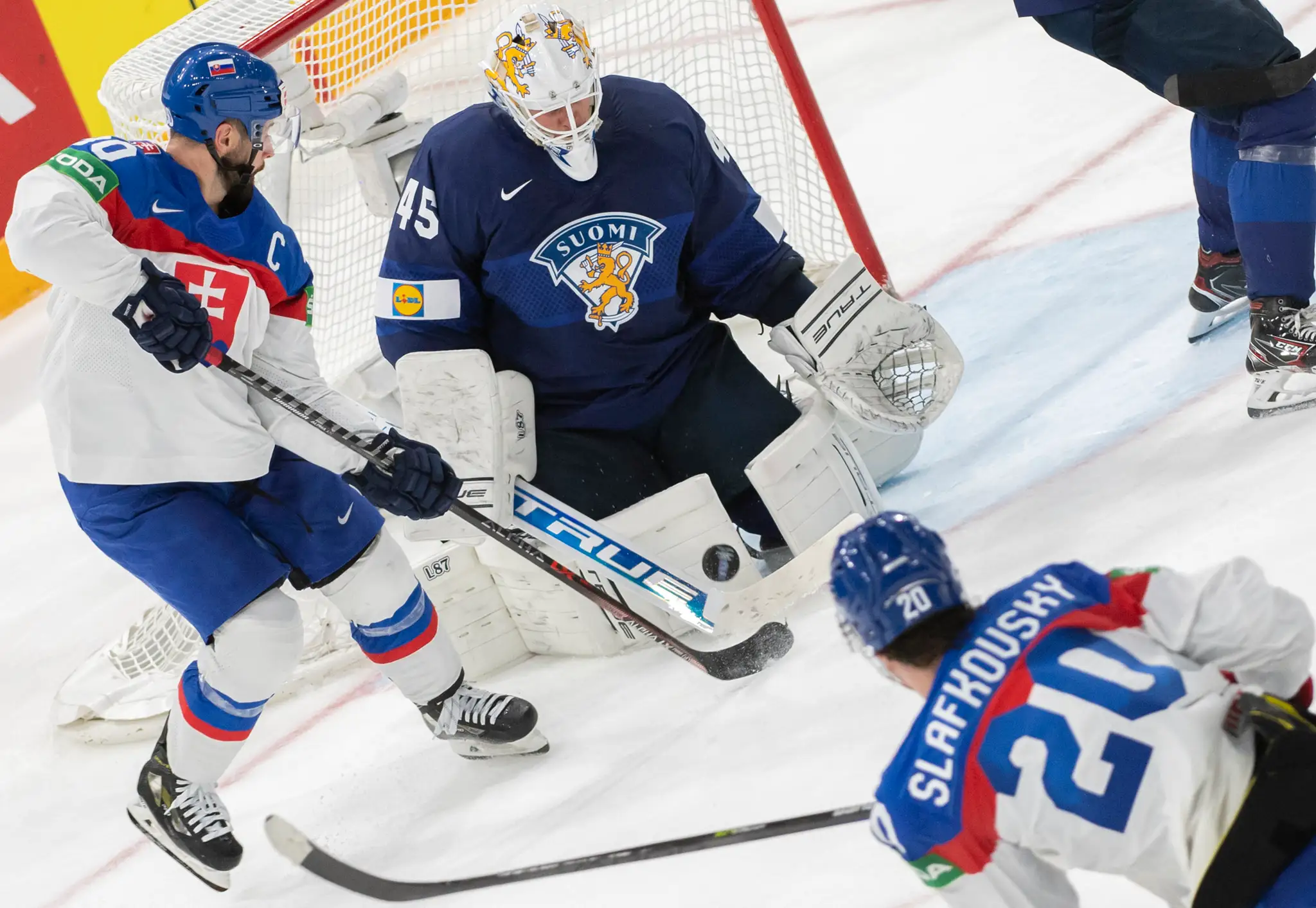 Na snímke vľavo kapitán slovenskej hokejovej reprezentácie Tomáš Tatar, vpravo spoluhráč Juraj Slafkovský a uprostred fínsky brankár Jussi Olkinoura vo štvrťfinále MS 2022.