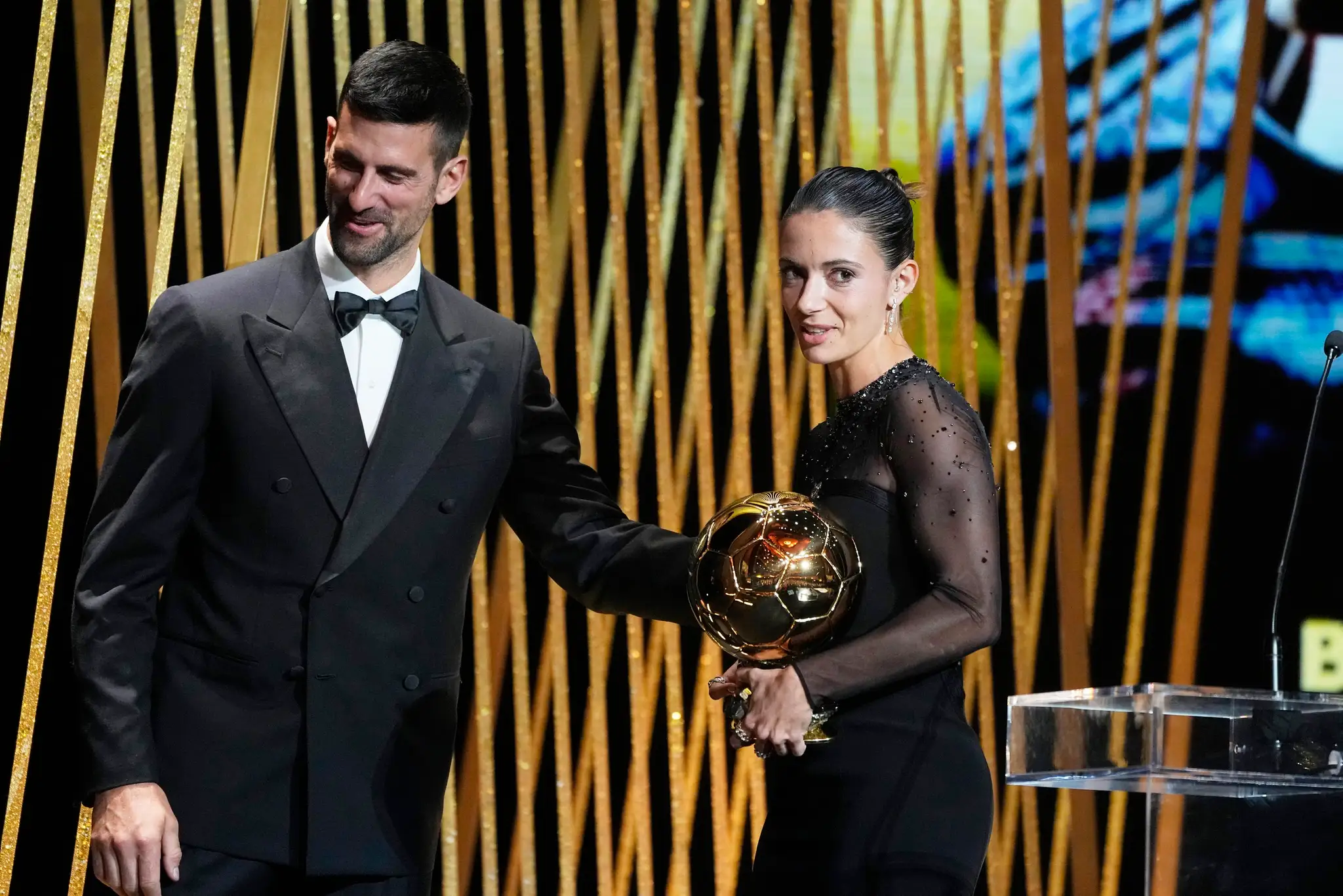 Aitana Bonmatiová si preberá Zlatú loptu z rúk Novaka Djokoviča.
