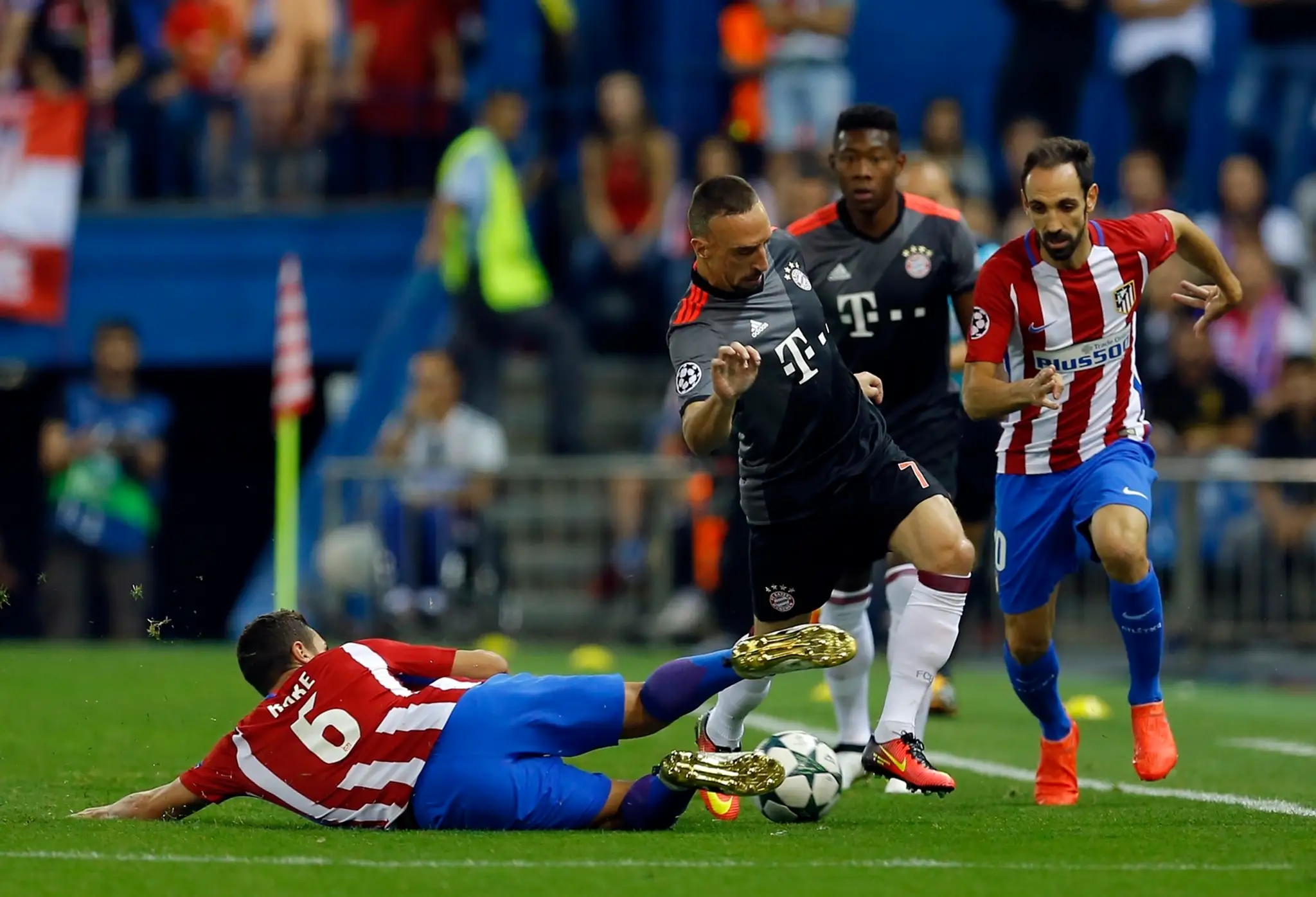 Koke (vľavo) z Atlética Madrid ostrým zákrokom zastavuje Francka Ribéryho (v strede) z Bayernu Mníchov, prizerá sa Juanfran.