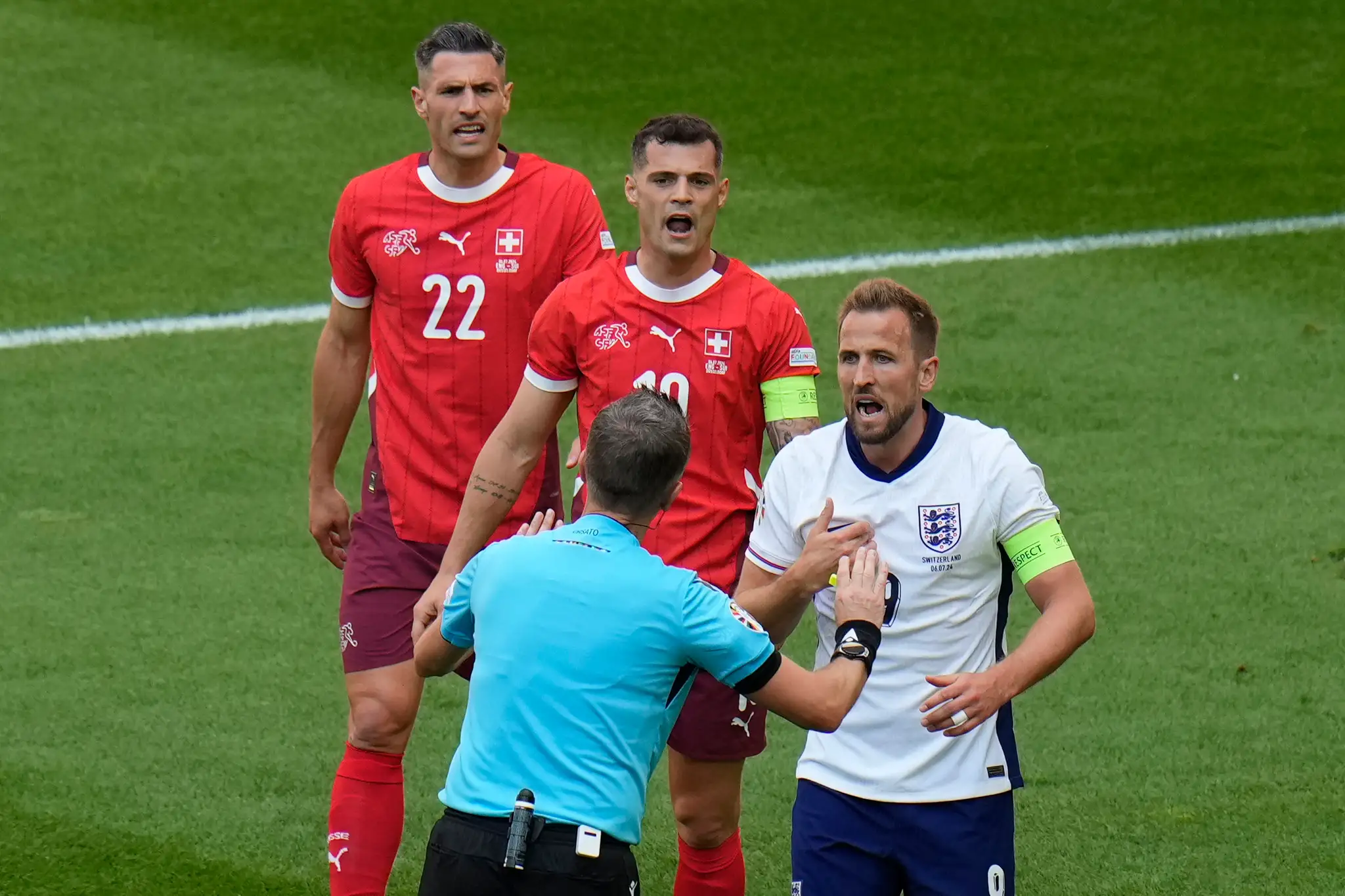 Anglický futbalista Harry Kane (vpravo) a diskutuje s rozhodcom Danielom Orsatom.