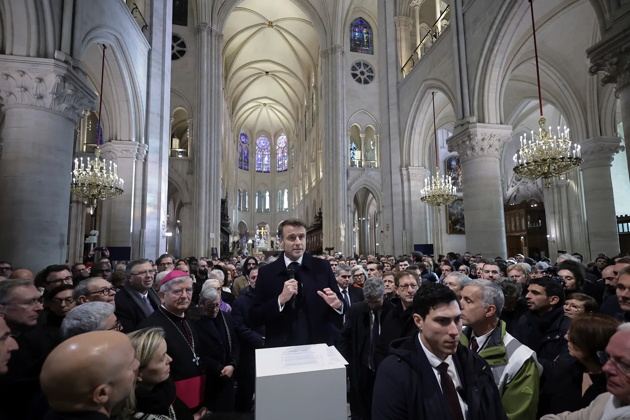 Na snímke francúzsky prezident Emmanuel Macron (uprostred) vystupuje s prejavom v zrekonštruovanej parížskej katedrále Notre- Dame.