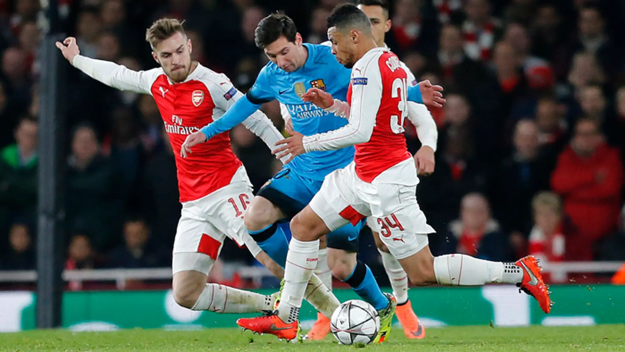 Hráč FC Barcelona Lionel Messi bojuje o loptu s hráčmi Arsenalu v osemfinále LM.