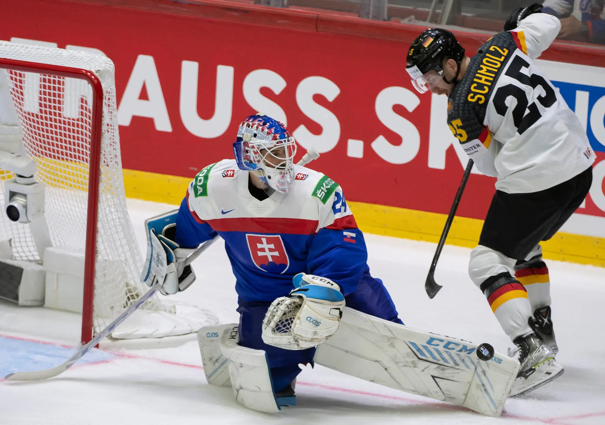 Na snímke zľava slovenský brankár Patrik Rybár a nemecký hokejista Daniel Schmolz.