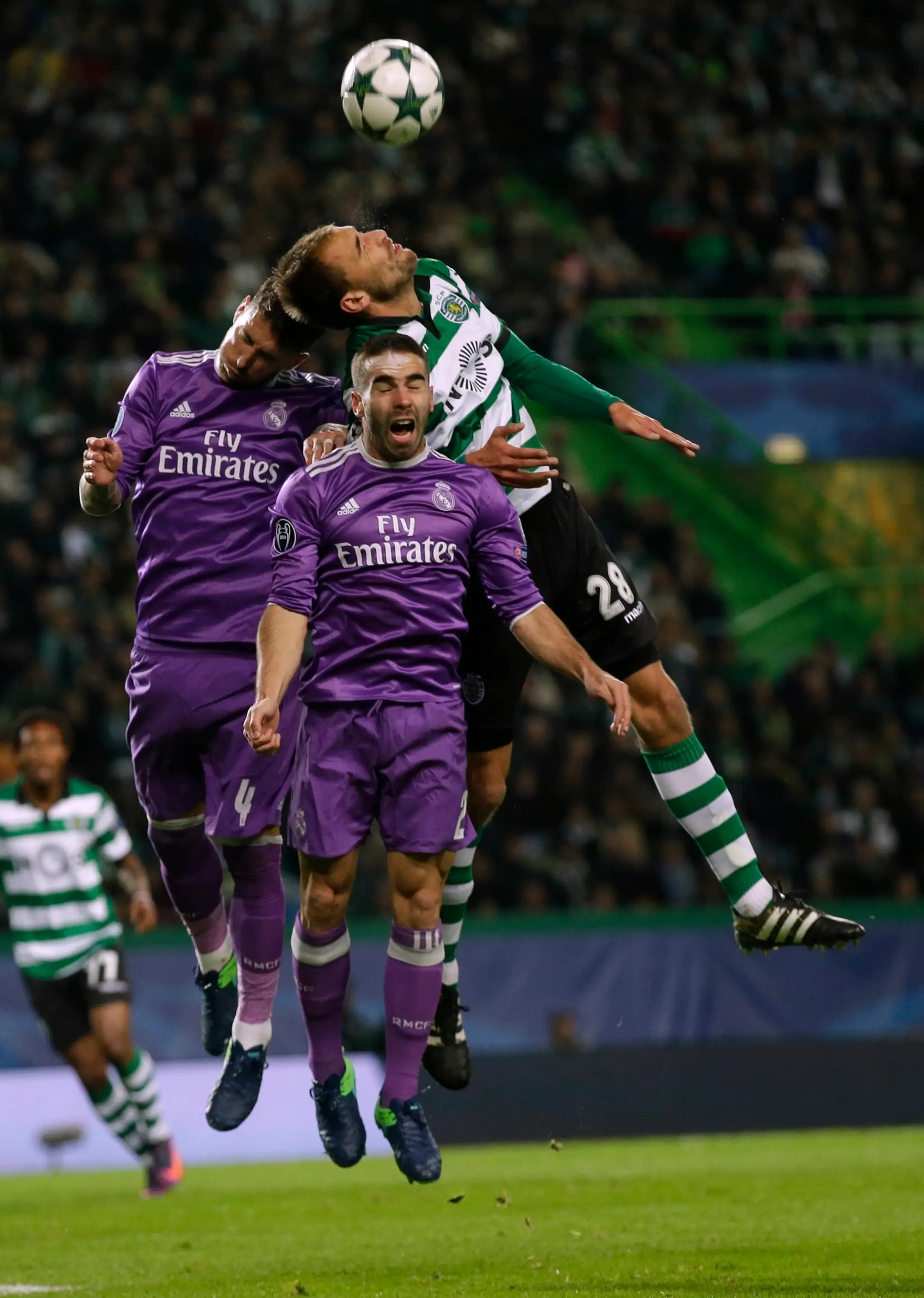 V hlavičkovom súboji Bas Dost zo Sportingu proti dvojici Dani Carvajal (vľavo) a Sergio Ramos z Realu Madrid.