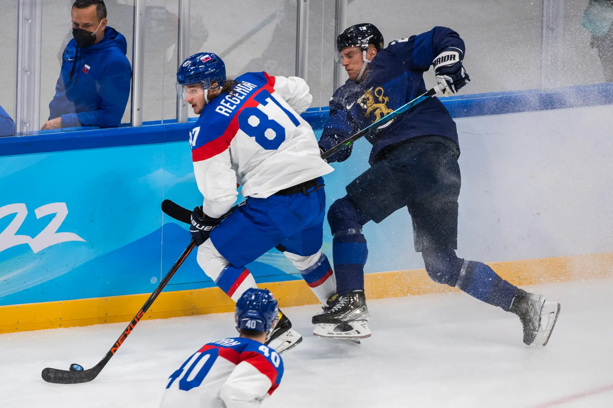 Zľava Pavol Regenda a Fín Joonas Nättinen bojujú o puk v dueli na ZOH 2022.