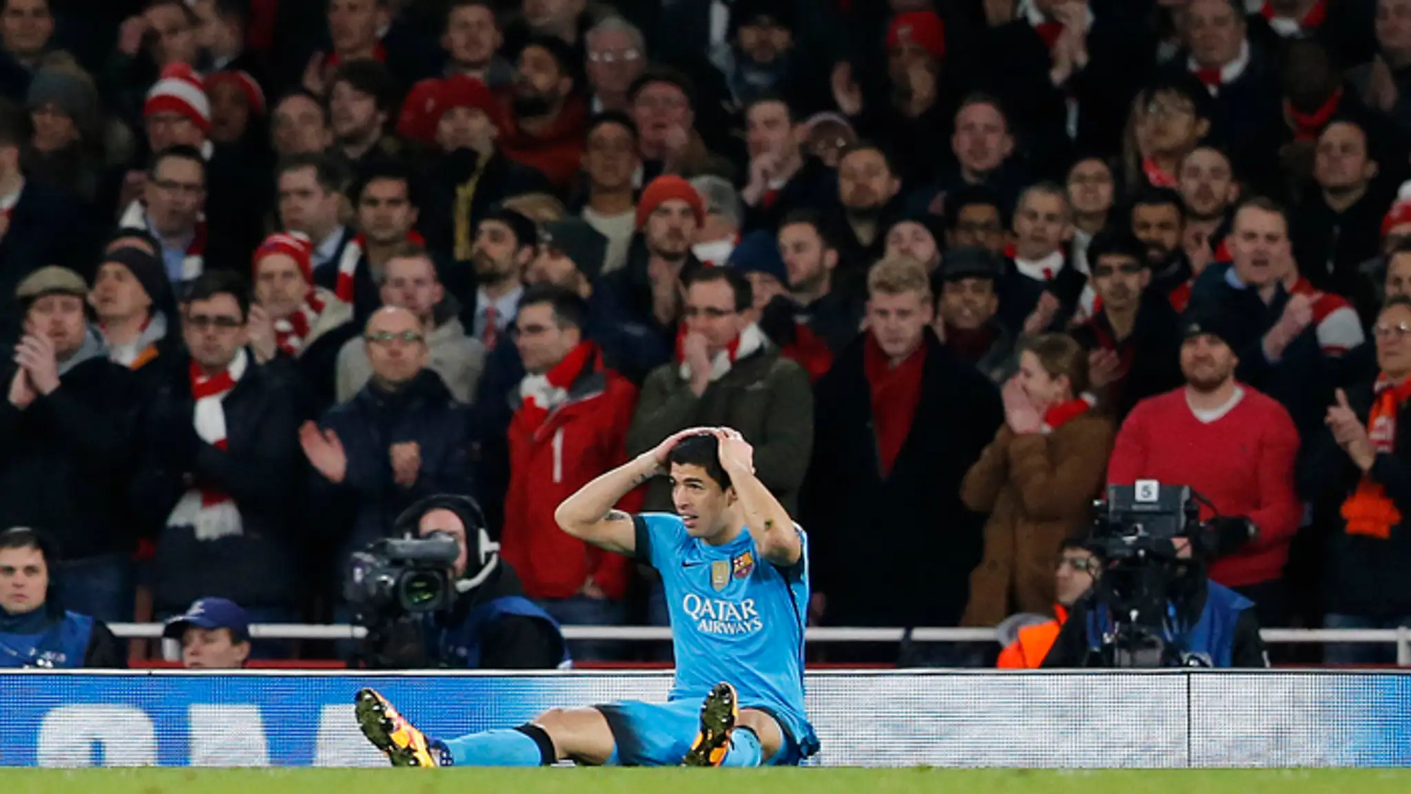 Luis Suarez (Barcelona) sedí na trávniku po tom, ako nepremenil šancu v osemfinále LM do bránky Arsenalu.