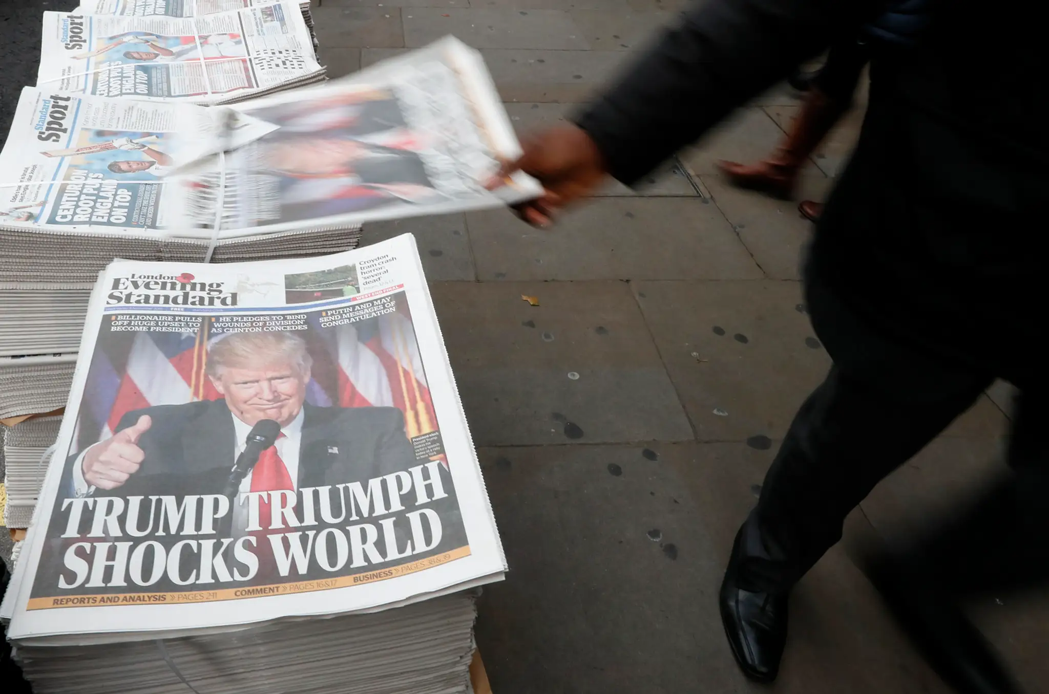 Chodci prechádzajú okolo novín Evening Standard s titulkom Trumpov triumf šokoval svet v Londýne 9. novembra 2016.