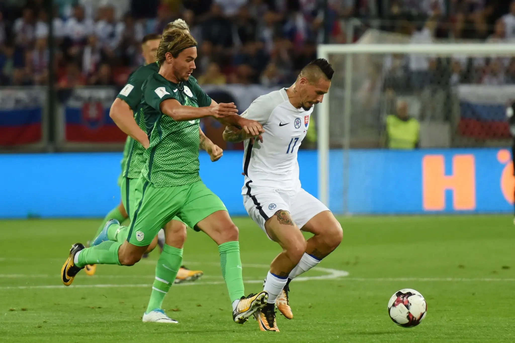 Na snímke vľavo hráč Slovinska René Krhin a kapitán Slovenska Marek Hamšík v zápase kvalifikácie MS.