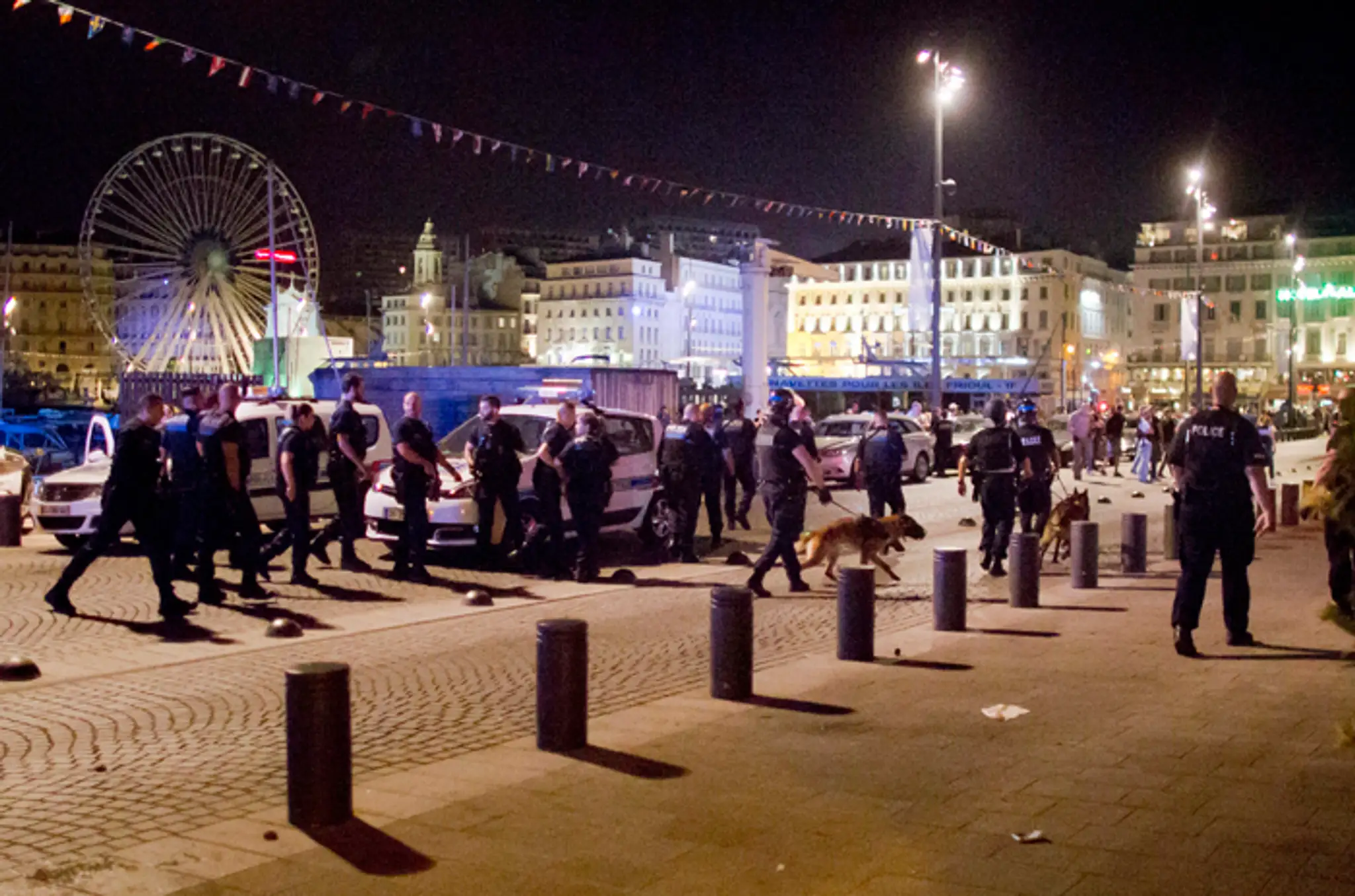 Francúzski policajti so psami hliadkujú na ulici po tom, čo sa strihla bitka medzi anglickými fanúšikmi a miestnymi.