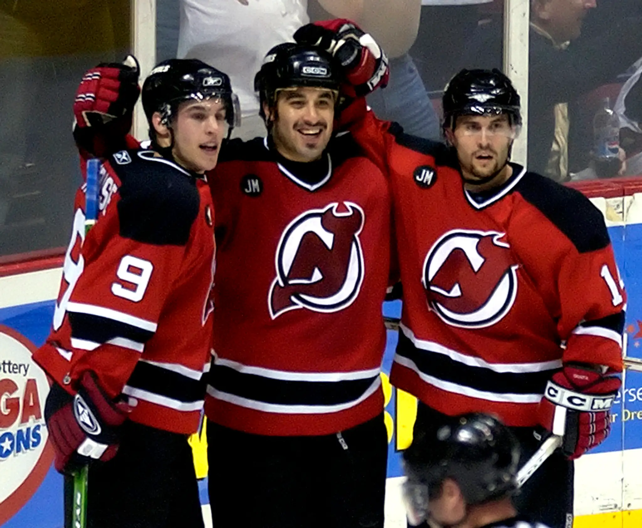Zach Parise a Brian Gionta sa tešia so Scottom Gomezom z jeho gólu proti Caroline Hurricanes