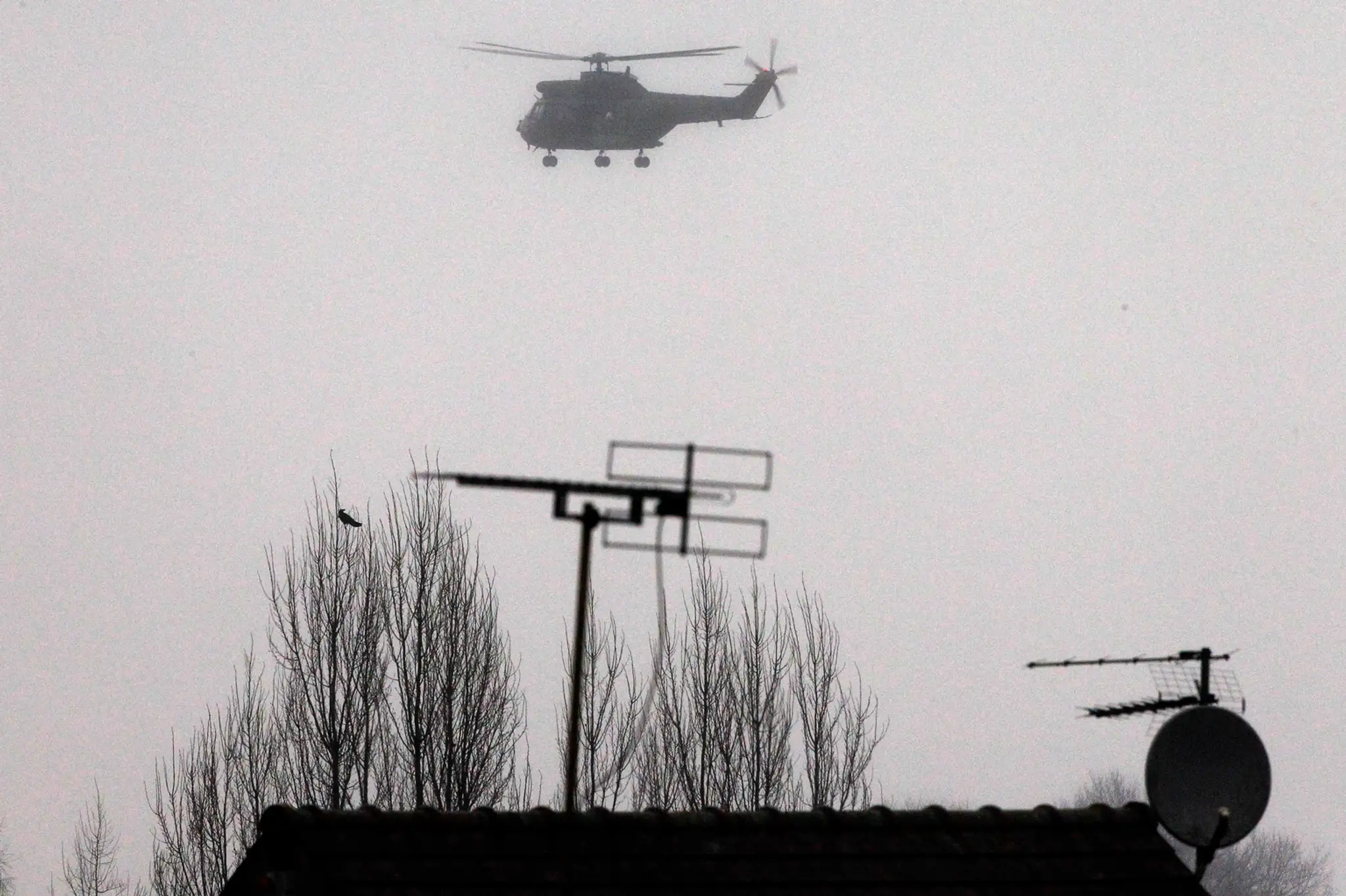 Policajná helikoptéra krúži nad mestom Dammartin-en-Goële , severovýchodne od Paríža 9. januára 2015.