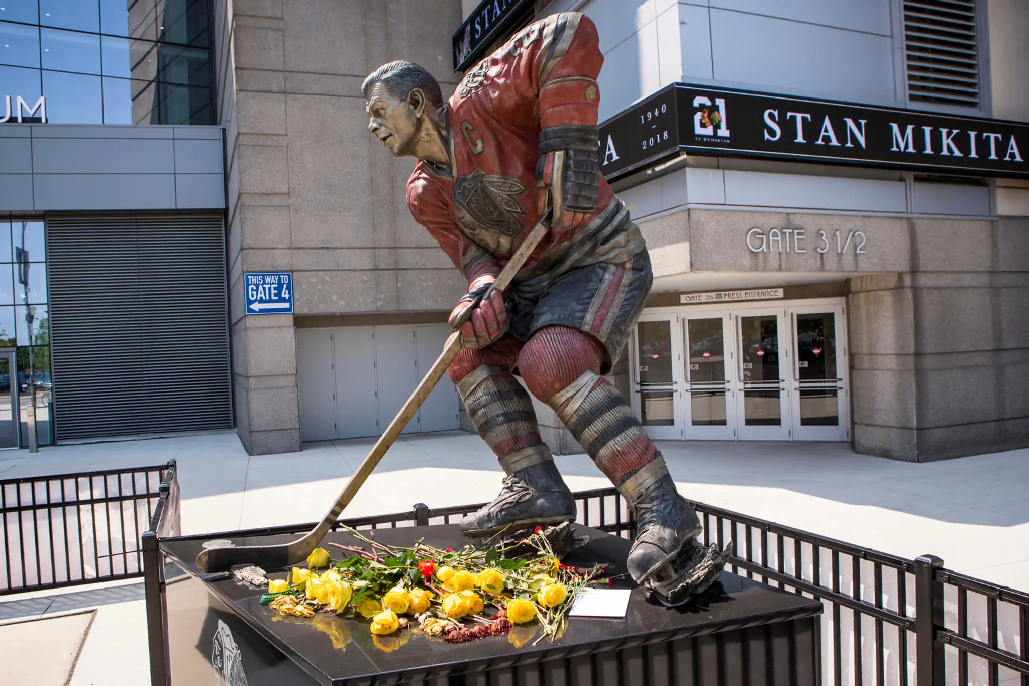Socha Stana Mikitu pred štadiónom United Center v Chicagu je obklopená kvetmi.
