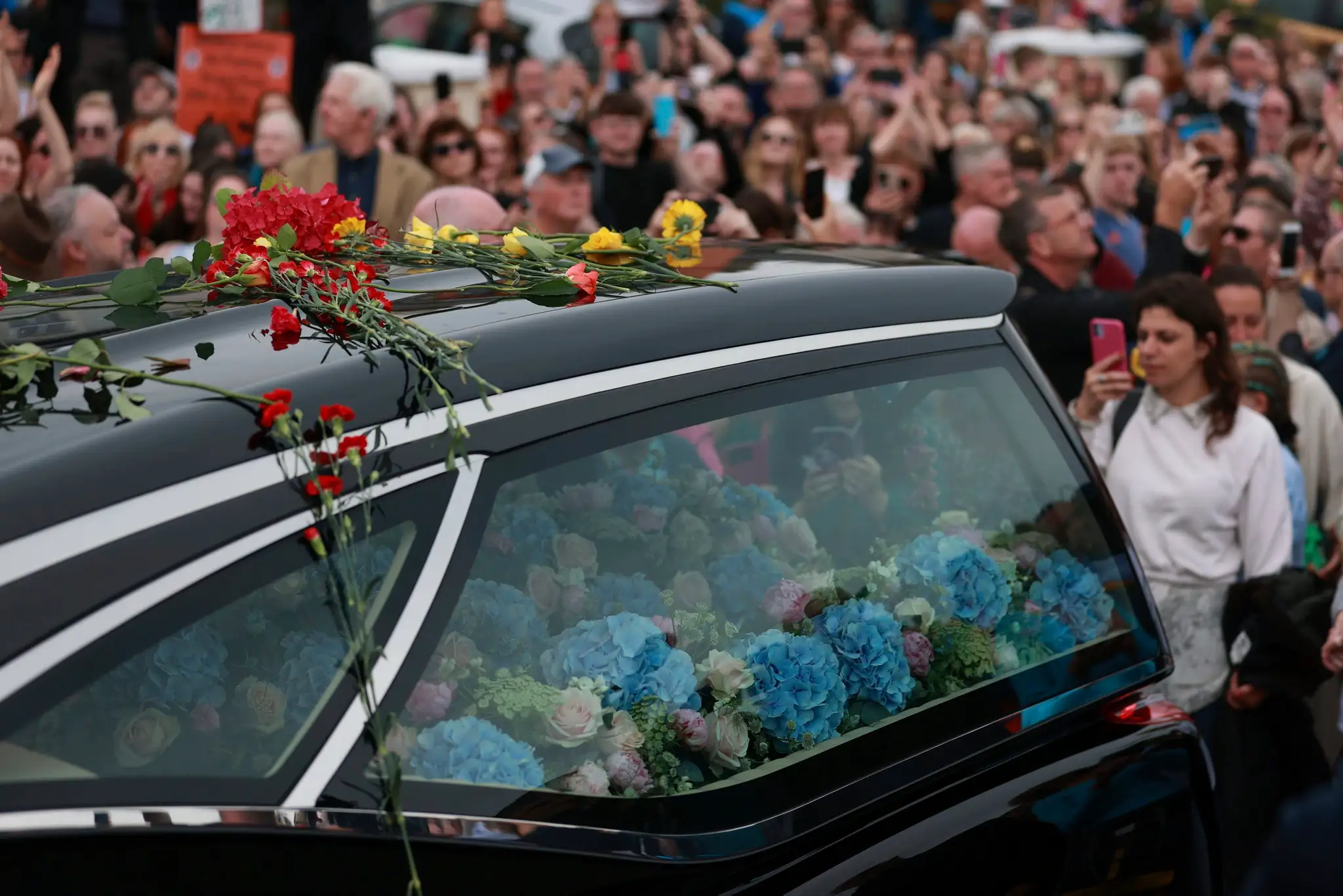Dav ľudí lemuje auto s pozostatkami Sinead O'Connor.