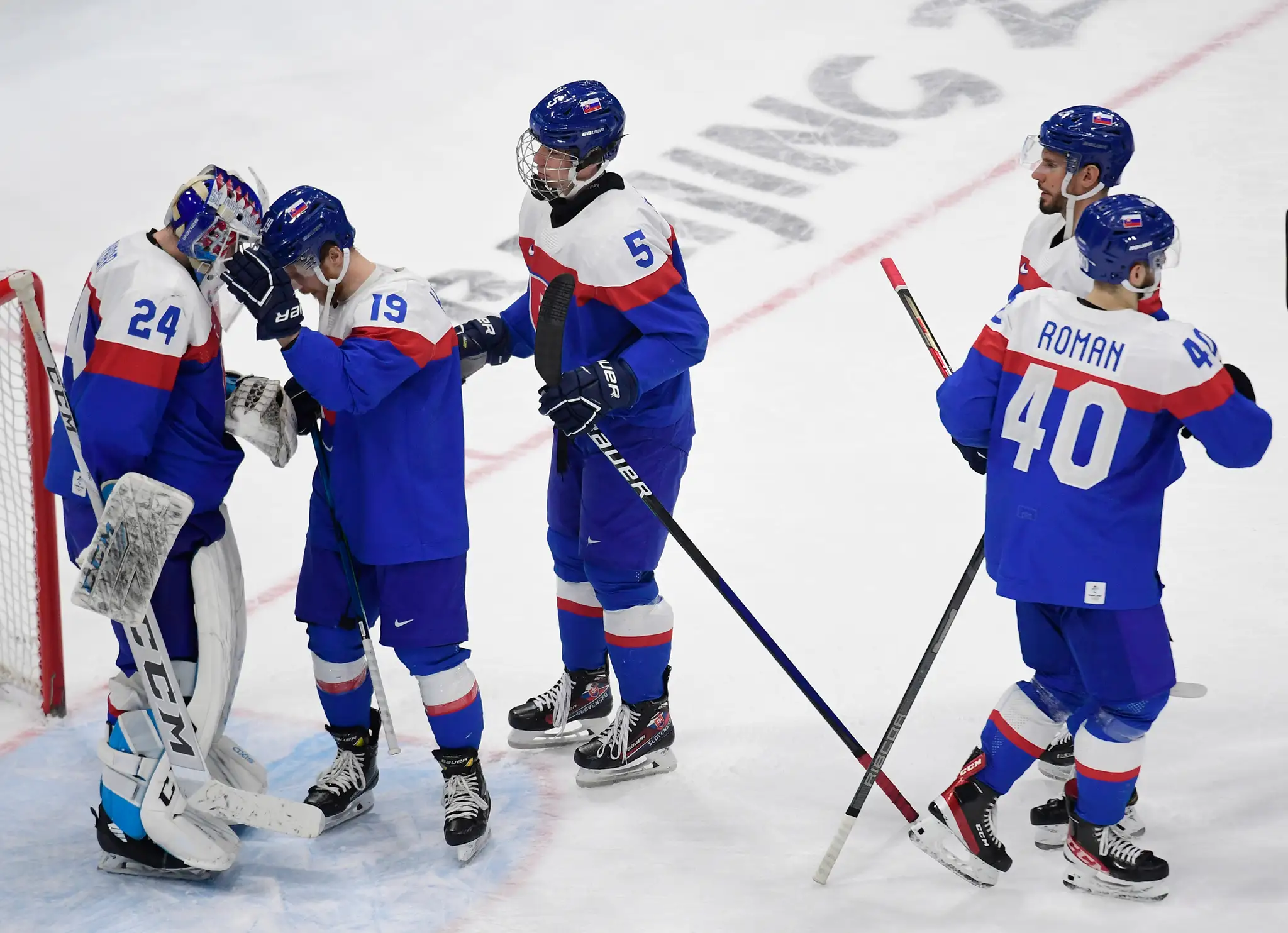 Slovenskí hokejisti ďakujú brankárovi Patrikovi Rybárovi za čisté konto a sa tešia po víťazstve 4:0 v kvalifikácii o štvrťfinále ZOH 2022 proti Nemecku.