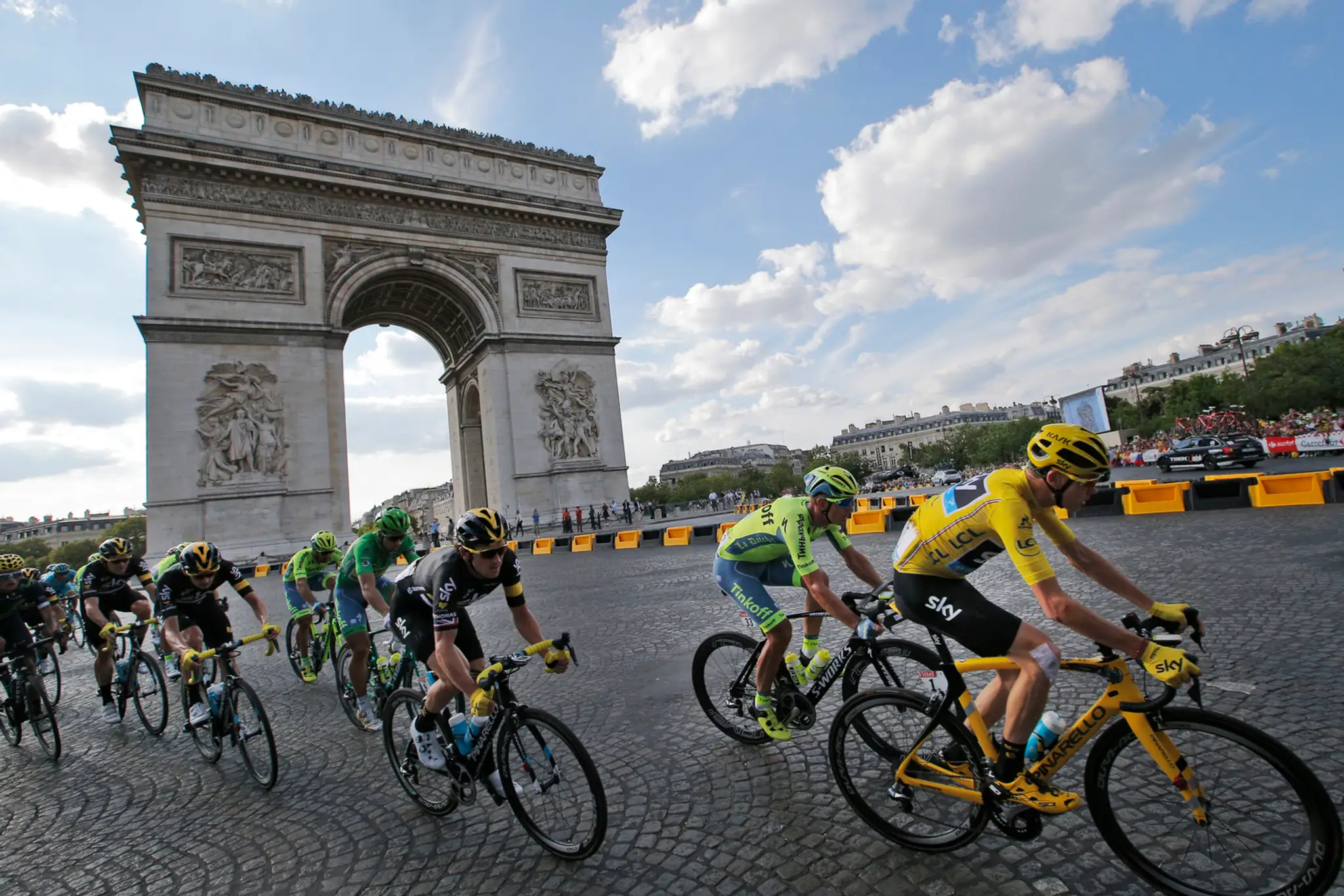 Chris Froome, Peter Sagan a spol. prechádzajú okolo Víťazného oblúka v poslednej etape Tour de France v Paríži.