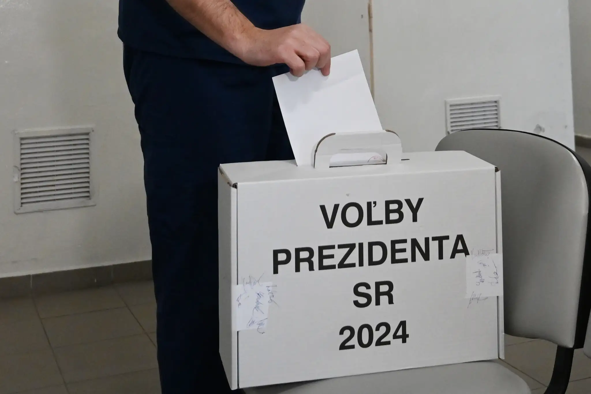 Na snímke lekár Fakultnej nemocnice Trnava vhadzuje obálku s hlasovacím lístkom do prenosnej volebnej schránky.