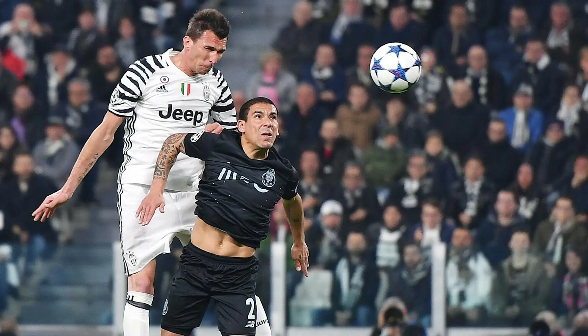 Mario Mandžukič (vľavo) z Juventusu hlavičkuje v odvete osemfinále LM pred Maxi Pereirom z Porta.