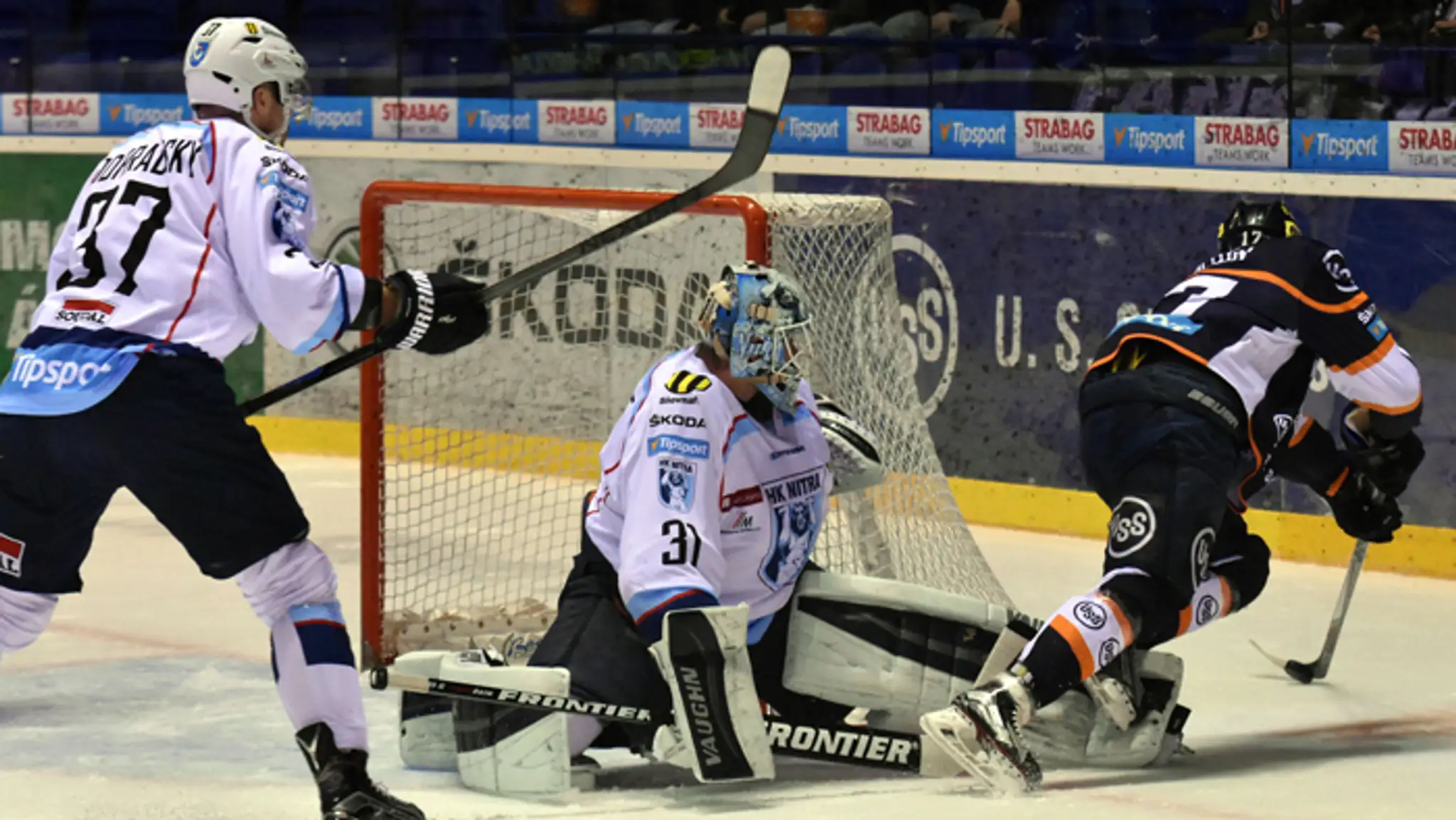 Brankár HK Nitra Michal Valent podráža hráča Petra Boltuna (HC Košice), vľavo Peter Podhradský (HC Nitra).