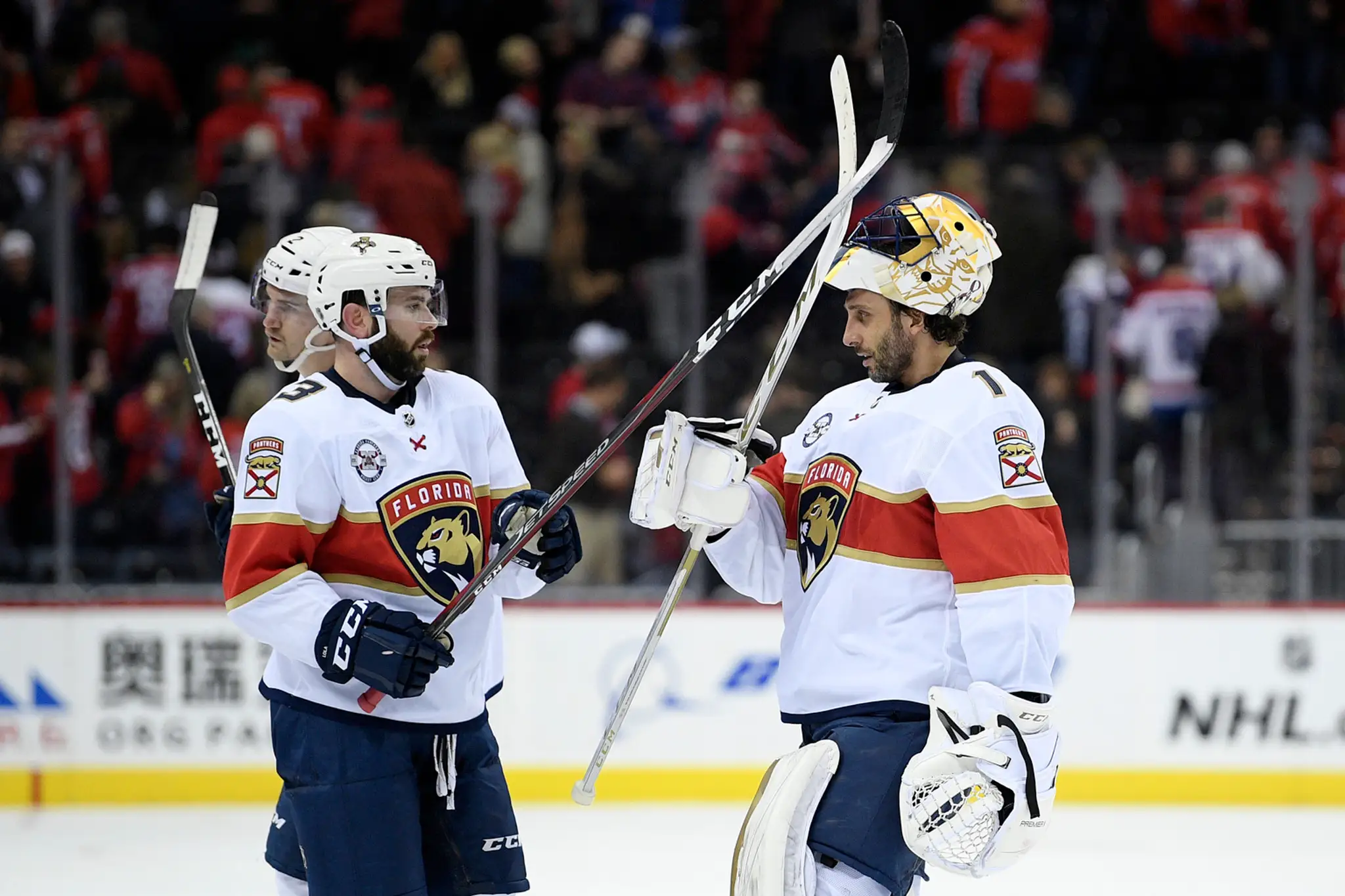 Zľava Mark Giordano, Johnny Gaudreau a Elias Lindholm z Calgary oslavujú gól proti Vancouveru.