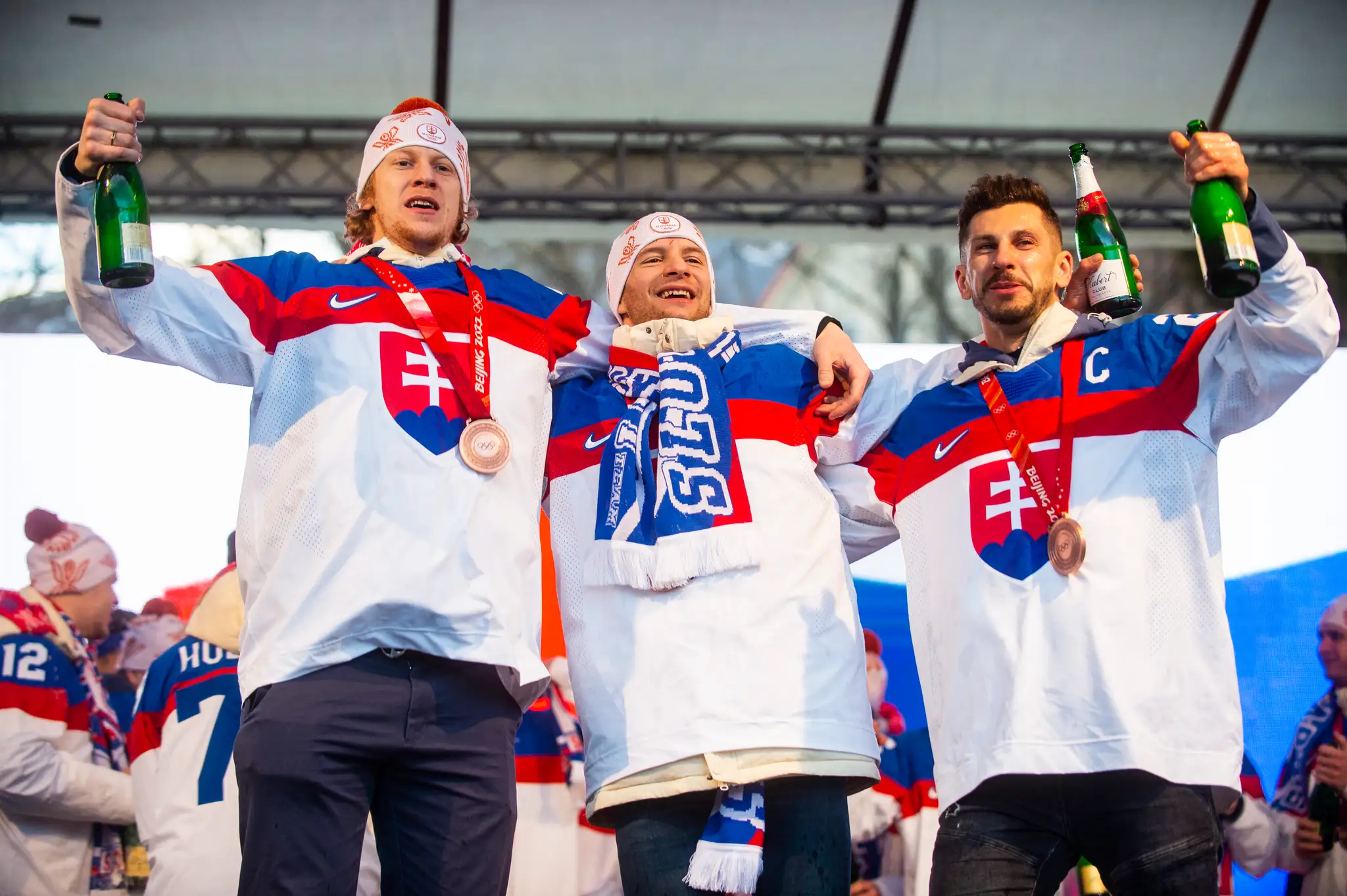 Zľava Michal Čajkovský, Mislav Rosandič a kapitán Marek Hrivík počas osláv bronzu zo ZOH 2022 na Námestí SNP v Bratislave.