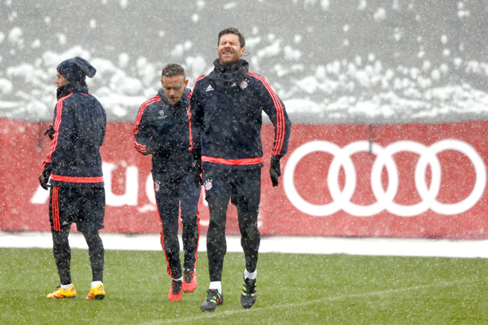 Futbalista Bayernu Mníchov Xabi Alonso (v popredí) zatvará oči na tréningu počas hustého sneženia pred odvetou LM.