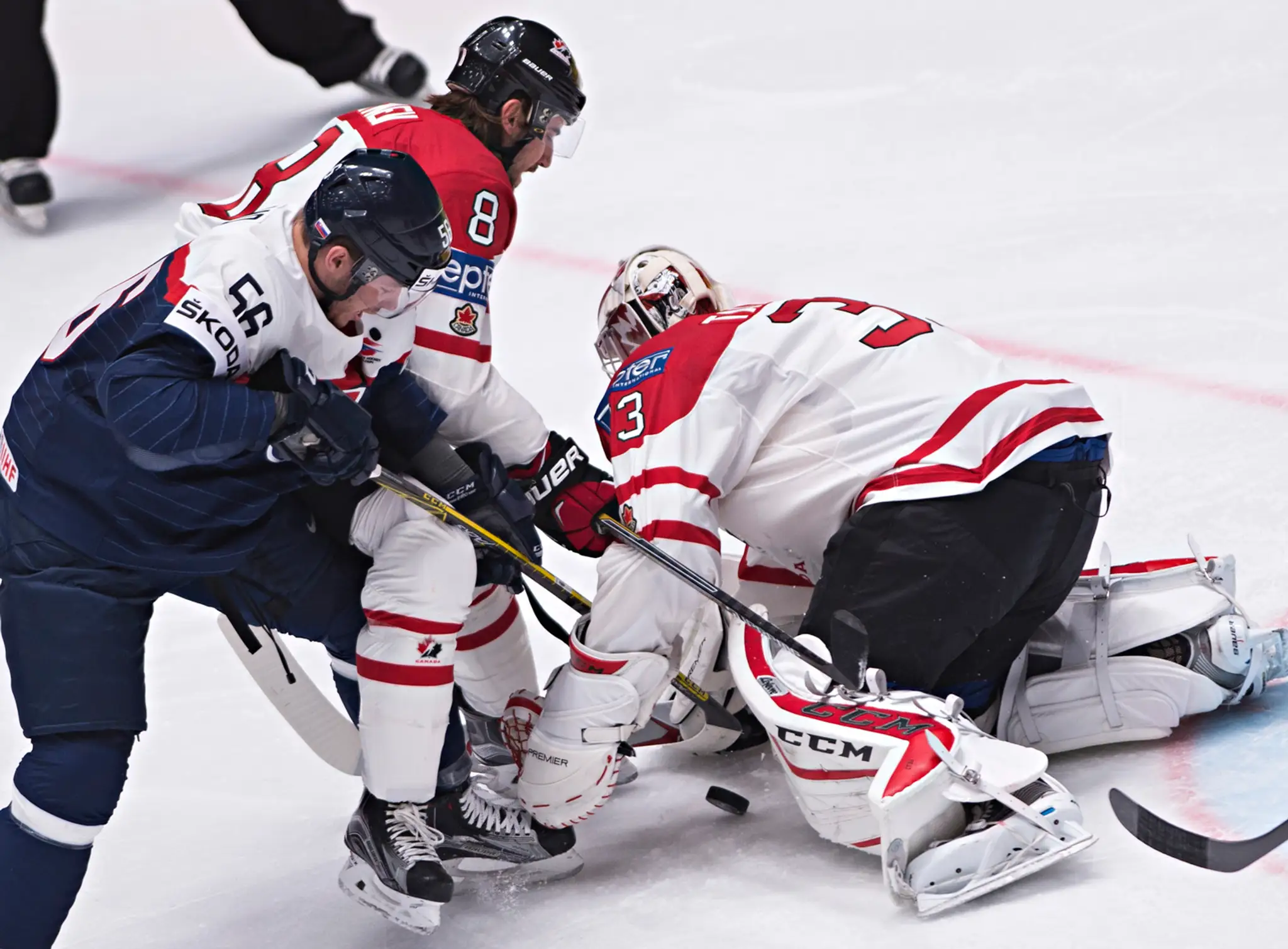 Na snímke vľavo Marko Daňo (Slovensko) Chris Tanev a brankár Cam Talbot (obaja Kanada) v zápase B-skupiny hokejových MS v Rusku.