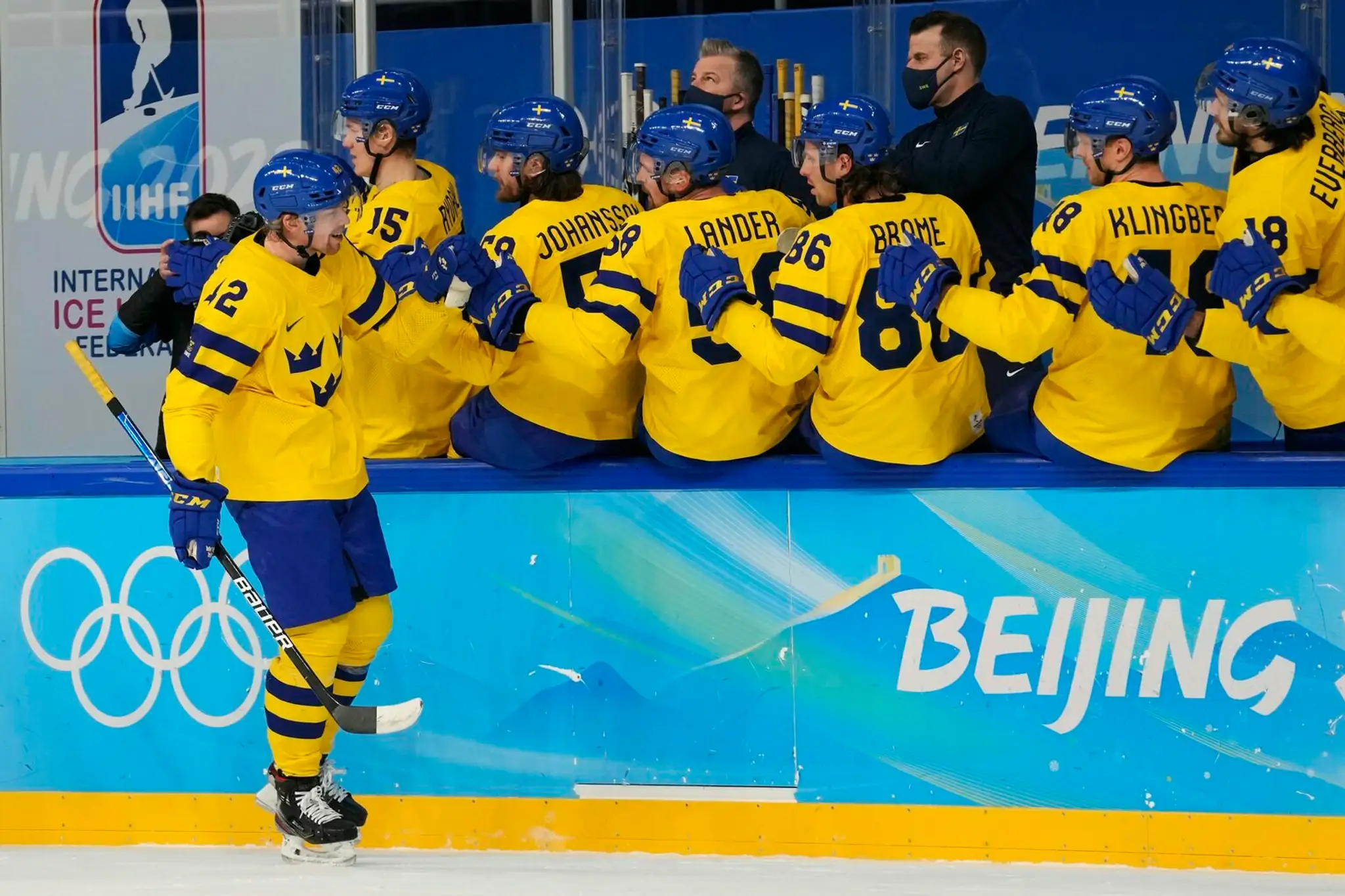 Joakim Nordstrom (na ľade) oslavuje so švédskymi spoluhráčmi gól proti Slovensku na ZOH 2022.
